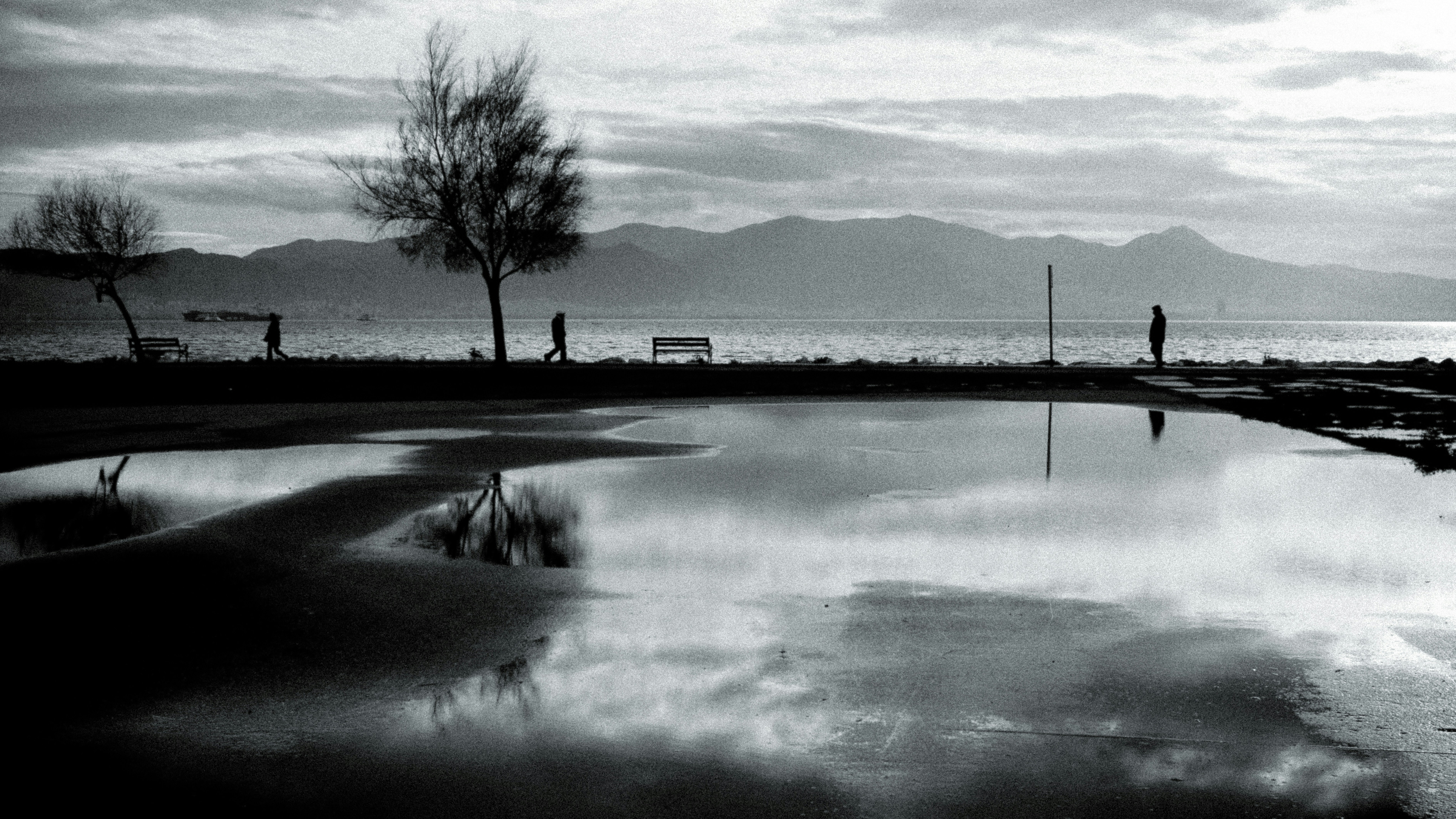 A grayscale landscape with reflections on water.