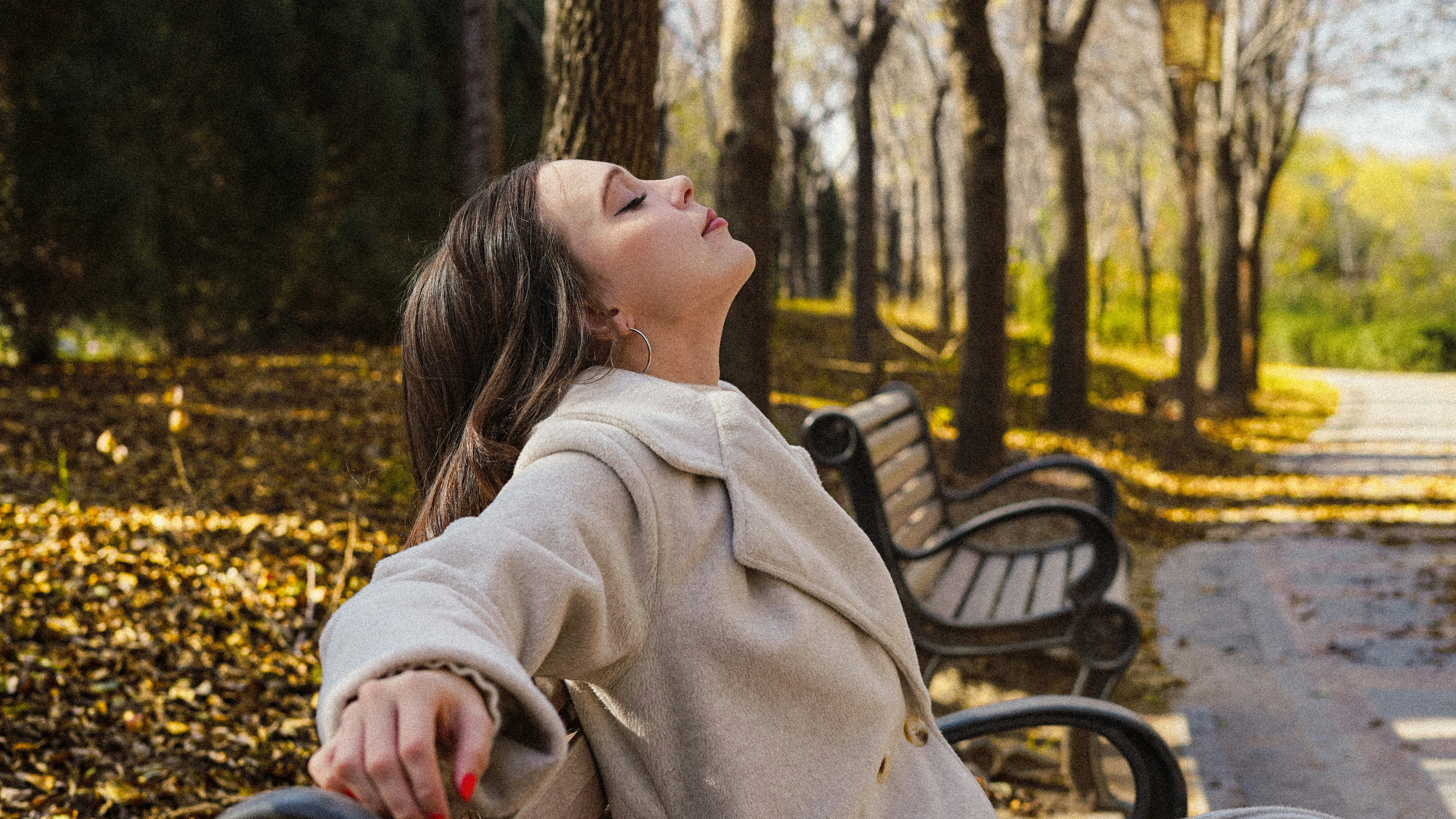 Woman relaxing on a park bench in autumn
