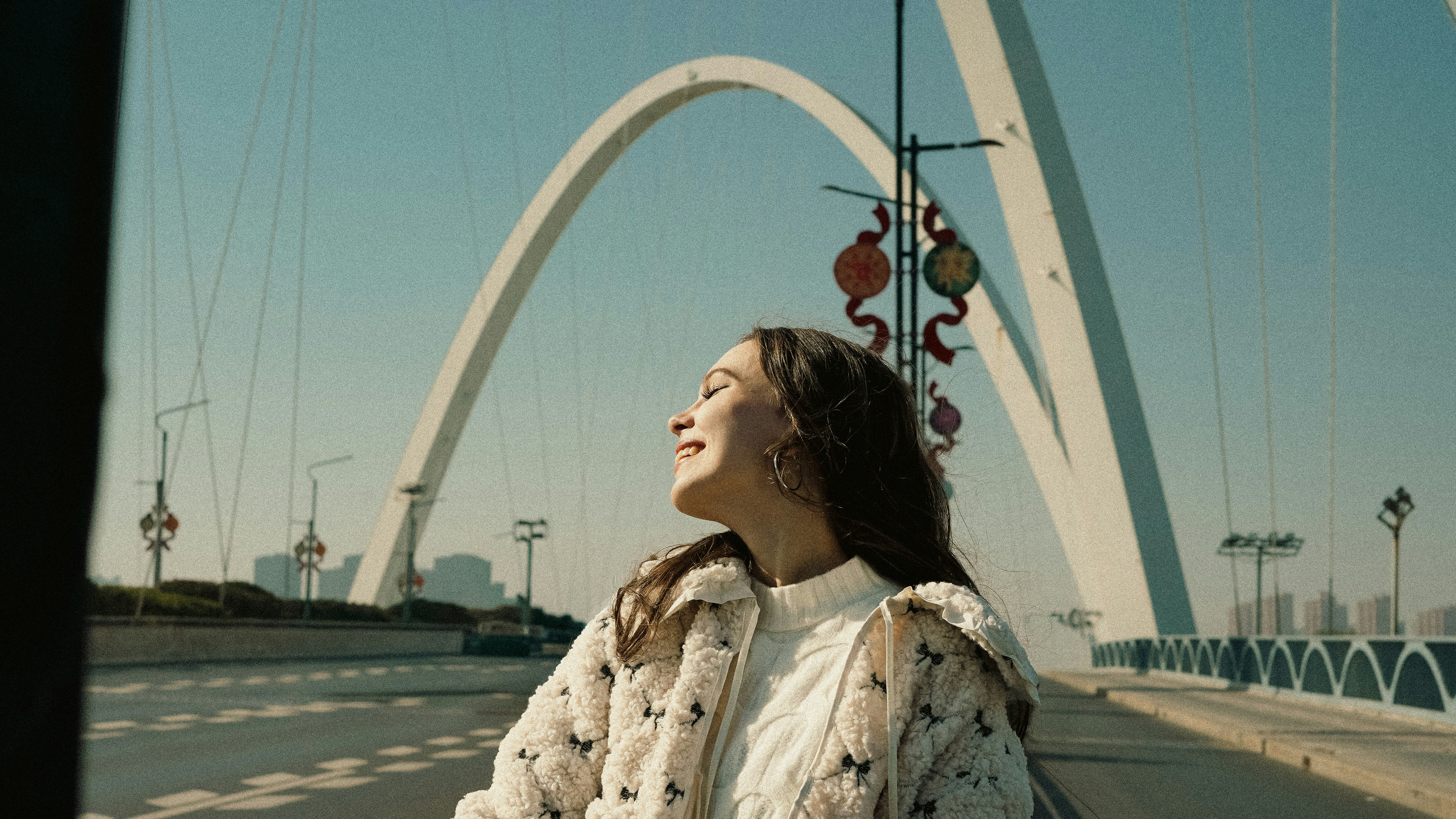 Young woman looking up at the sky on a bridge