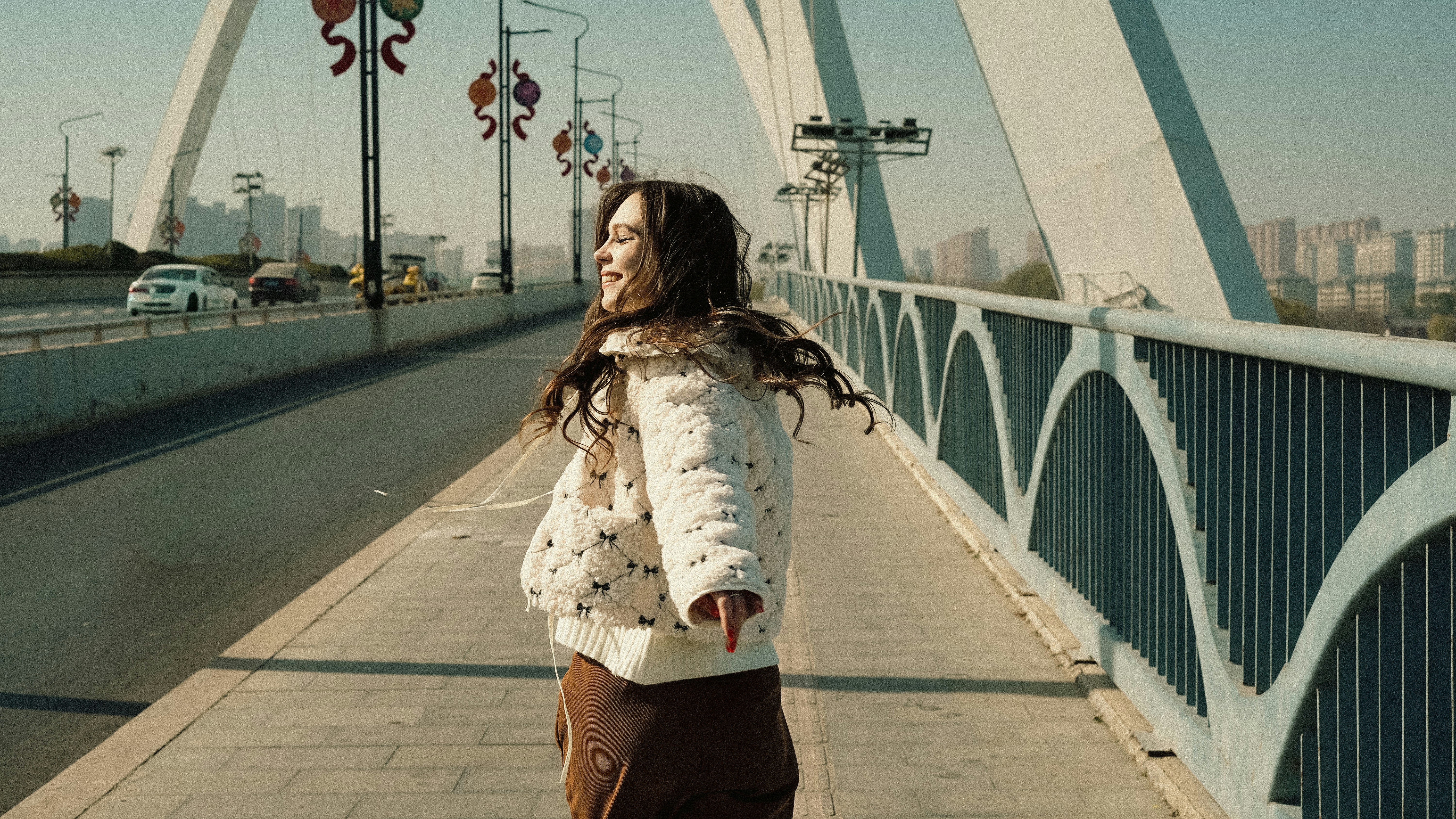 Young woman walking on a bridge with city skyline
