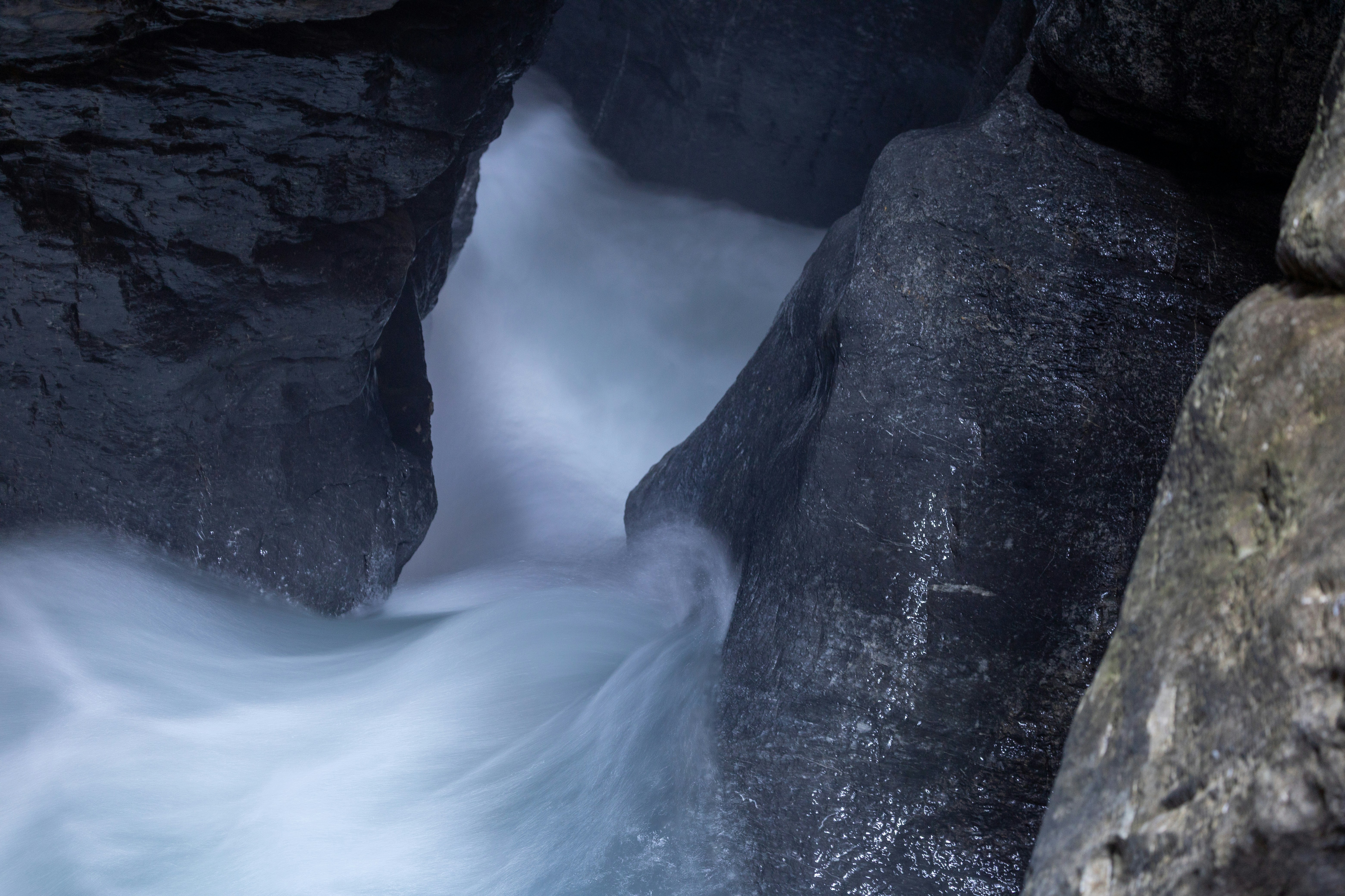 White water rapids flow through dark rocky gorge