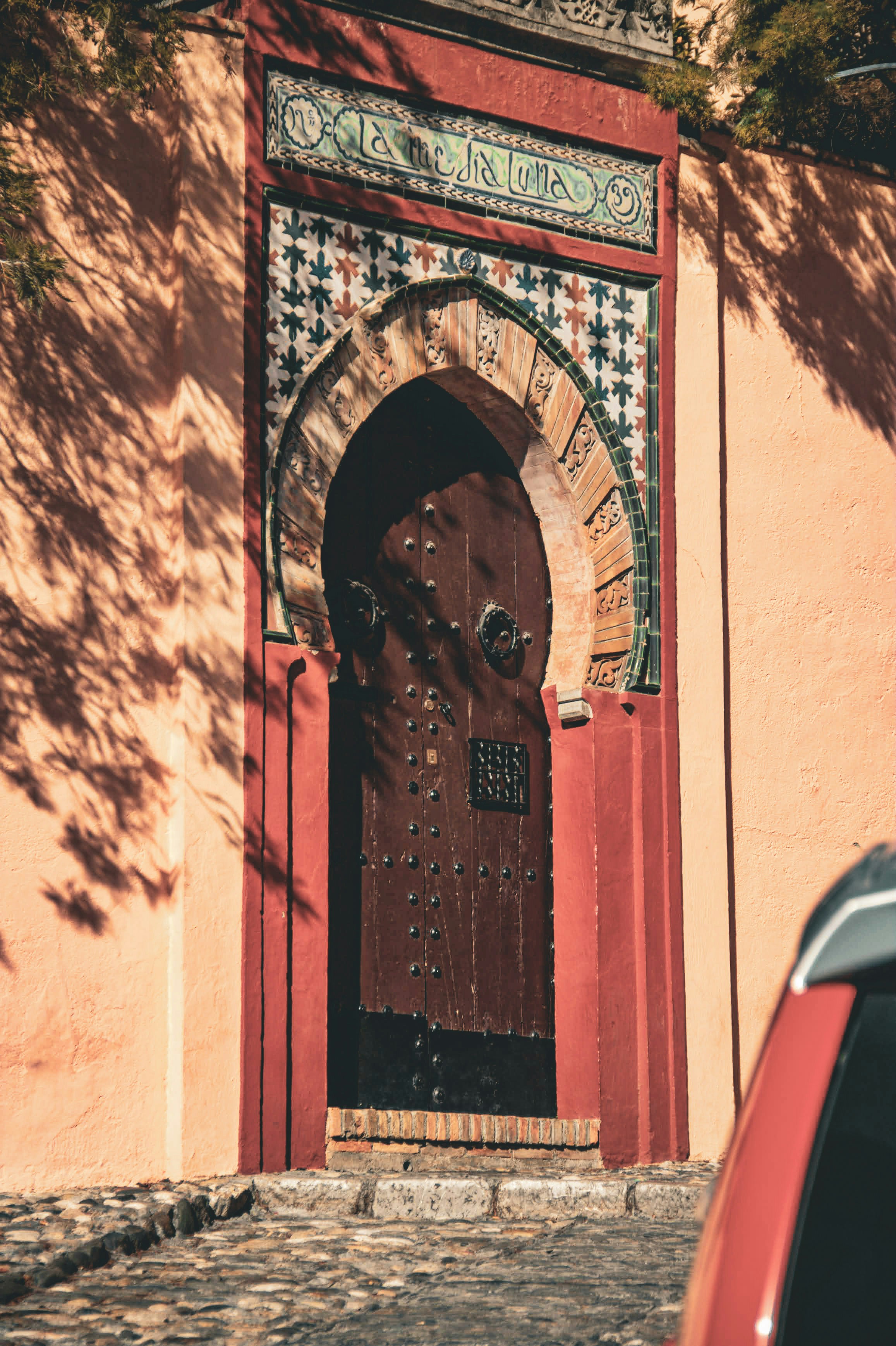 Ornate wooden door with intricate tilework and archway