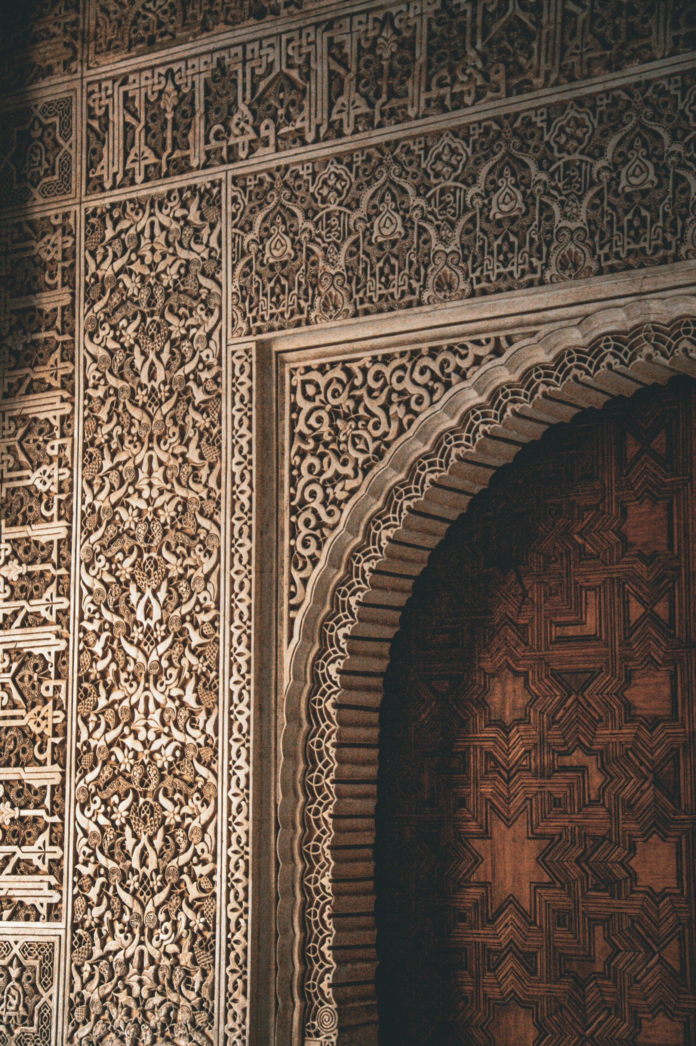 Intricate arabic geometric patterns adorn a wall and doorway.