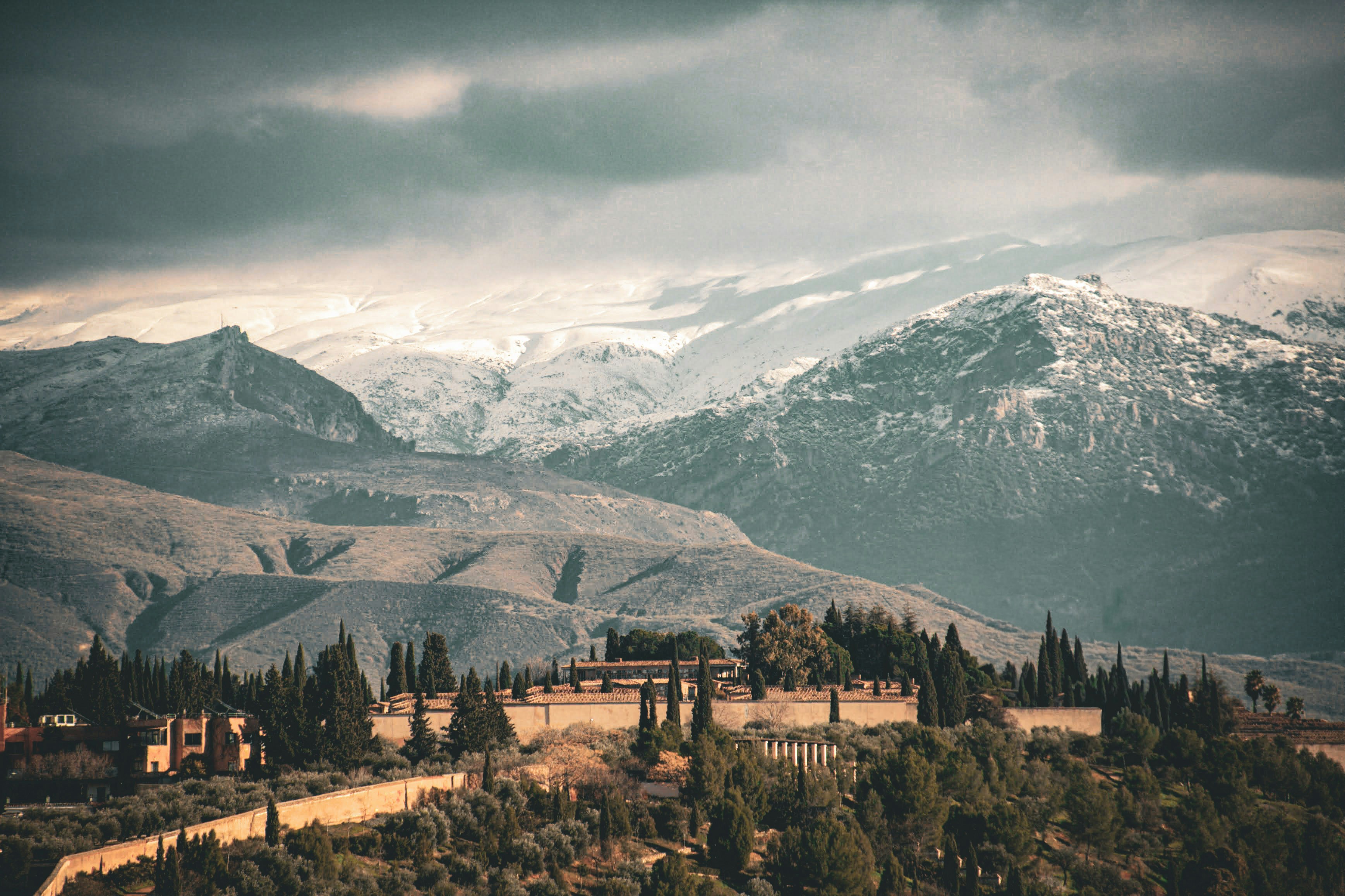Historic fortress on a hill with snowy mountains behind