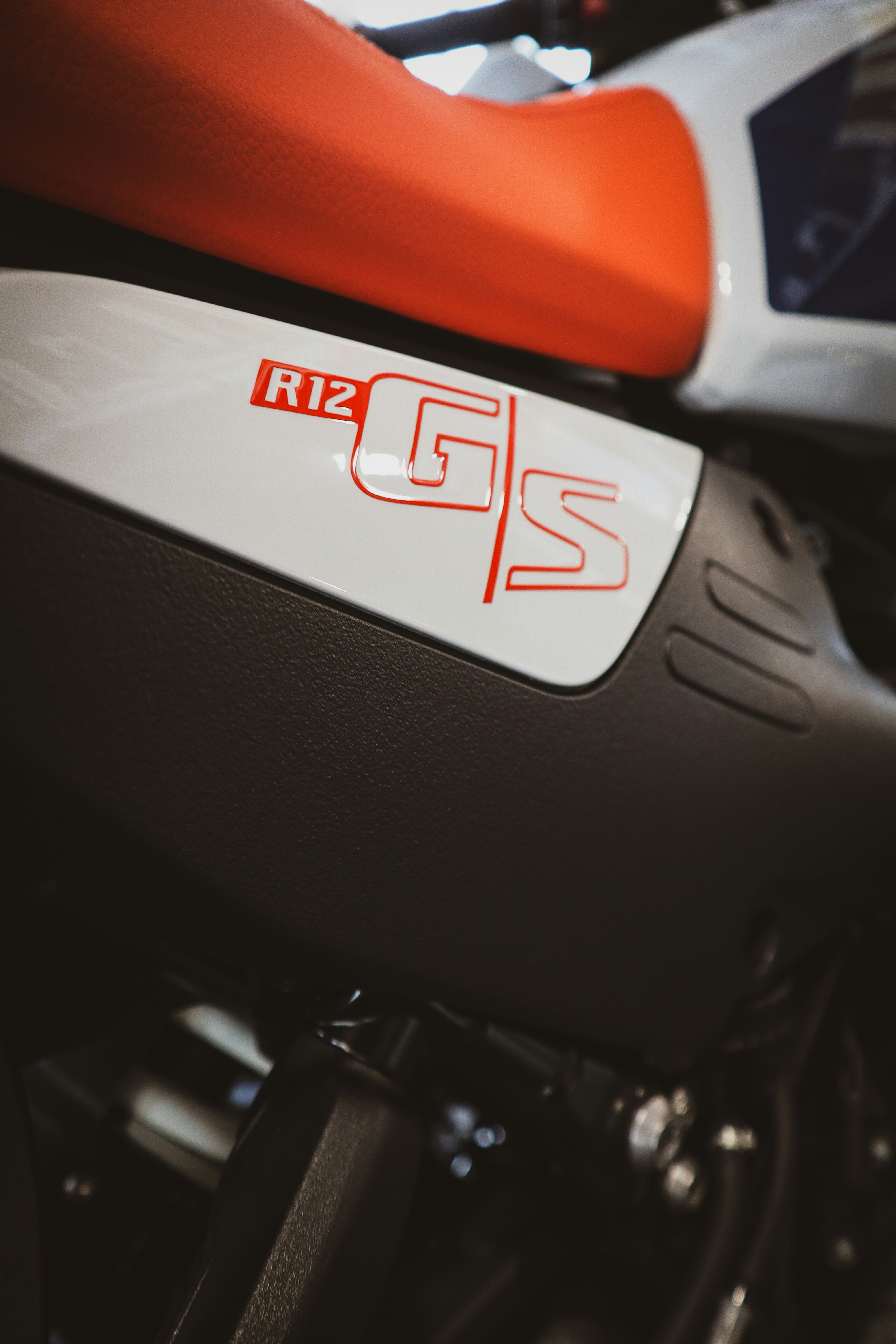 Close-up of a white motorcycle with red r12 gs logo.