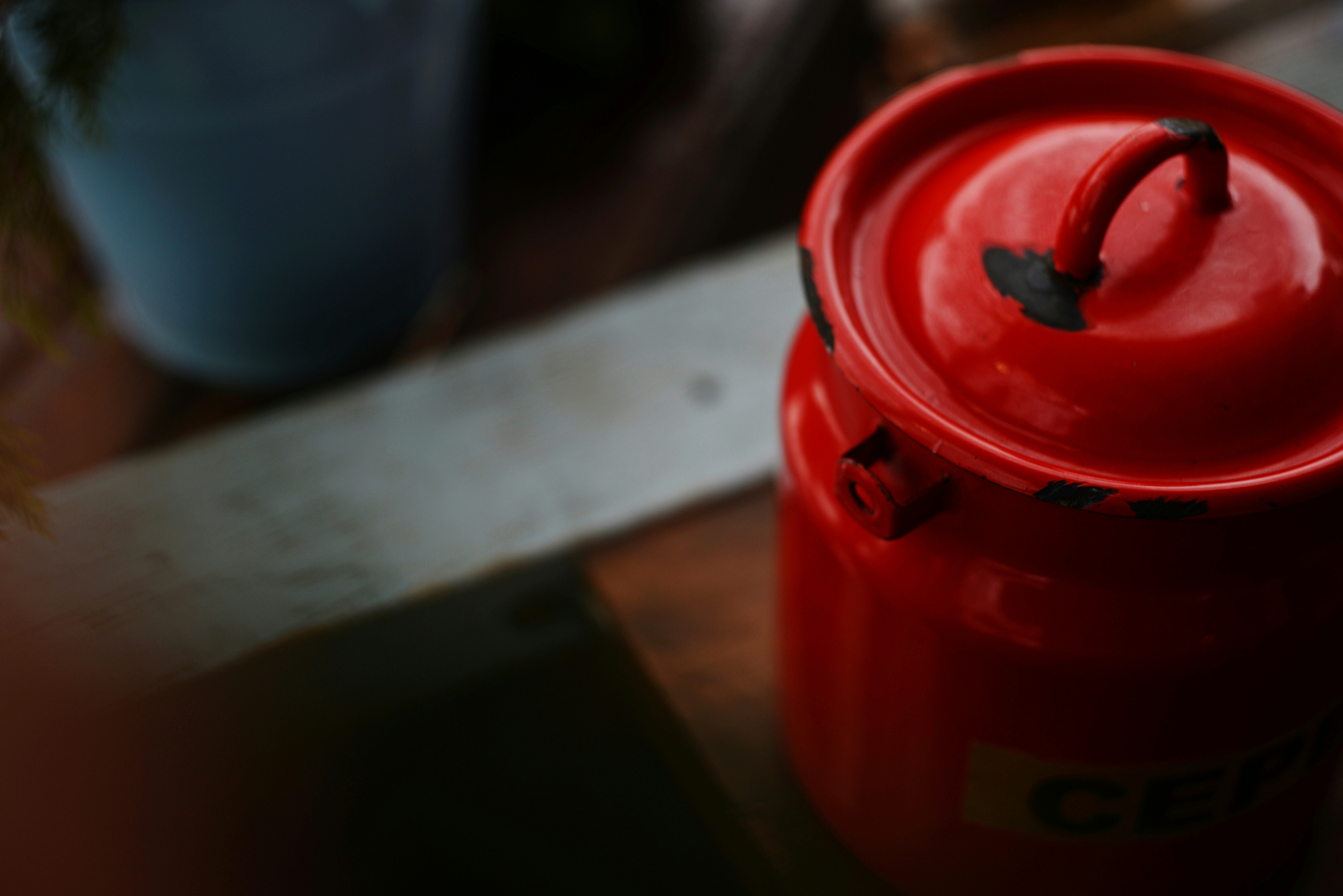 A bright red canister with a handle on top.