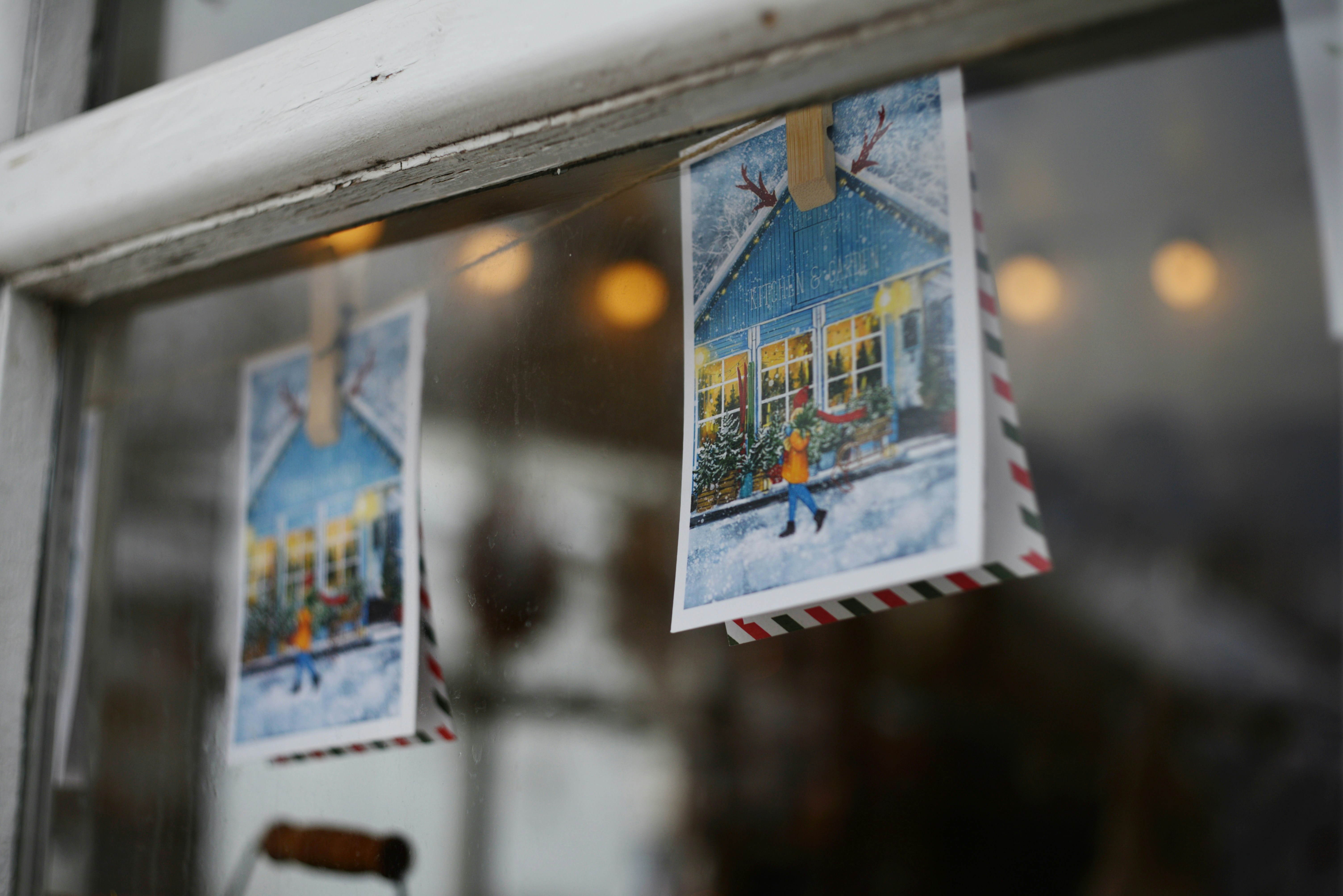 Deux cartes de vœux accrochées à une fenêtre