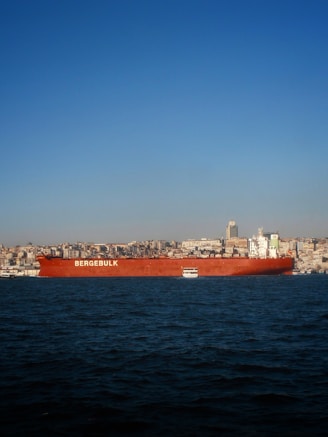 Large red cargo ship sailing on the water.