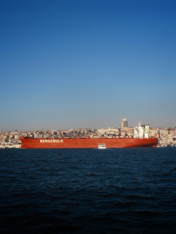 Large red cargo ship sailing on the water.