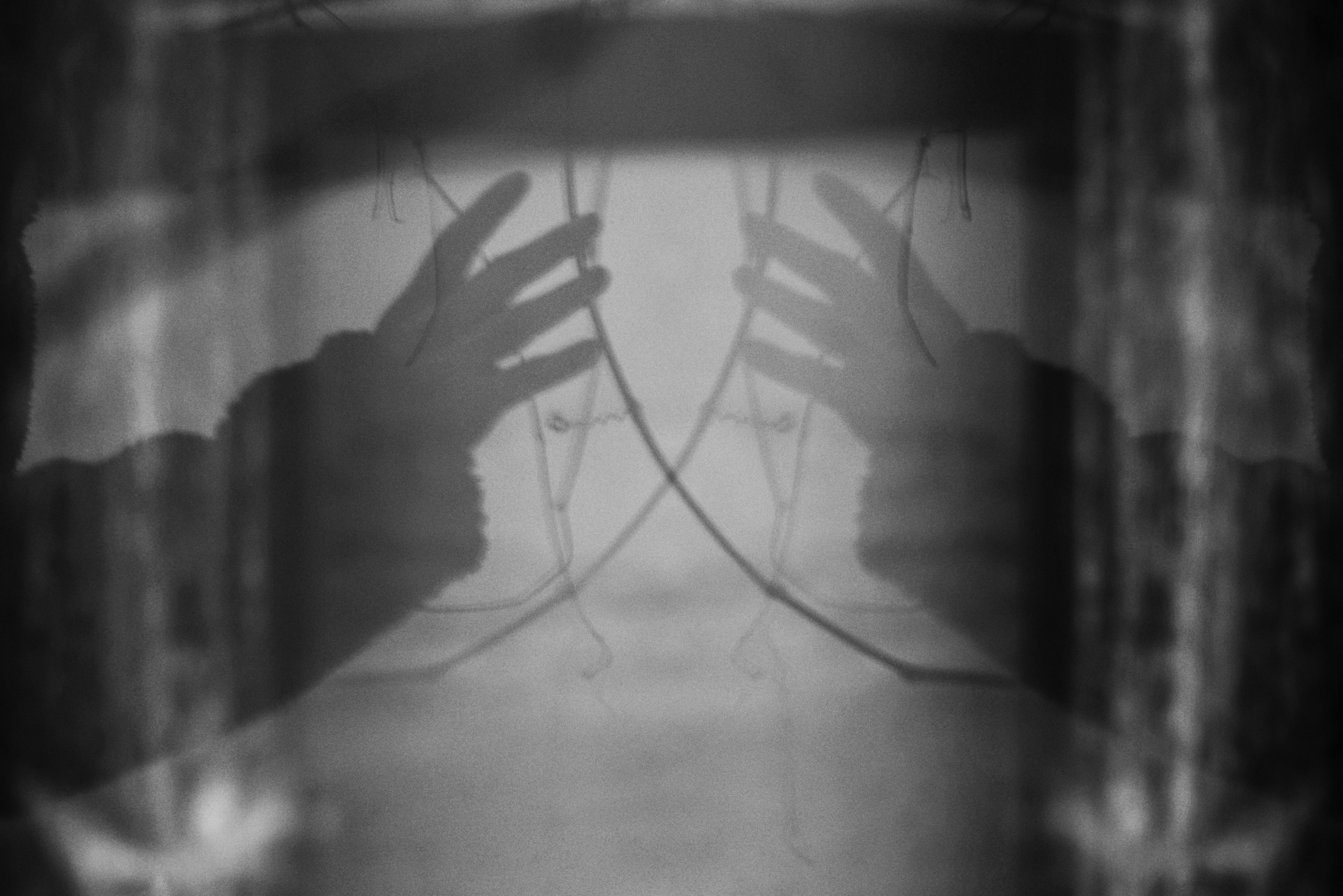 Reflet abstrait de mains dans un cadre flou et sombre.