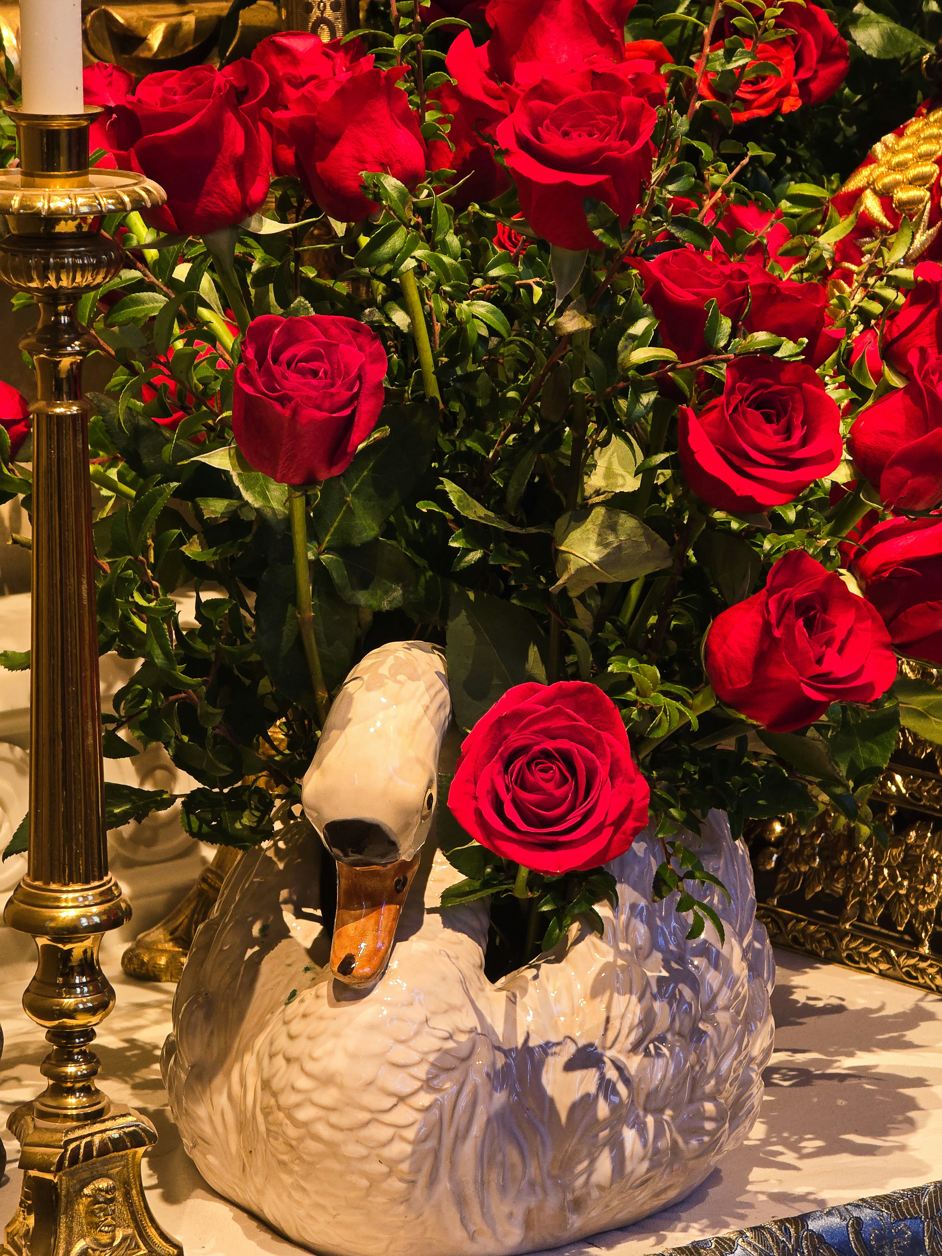 A swan planter filled with red roses