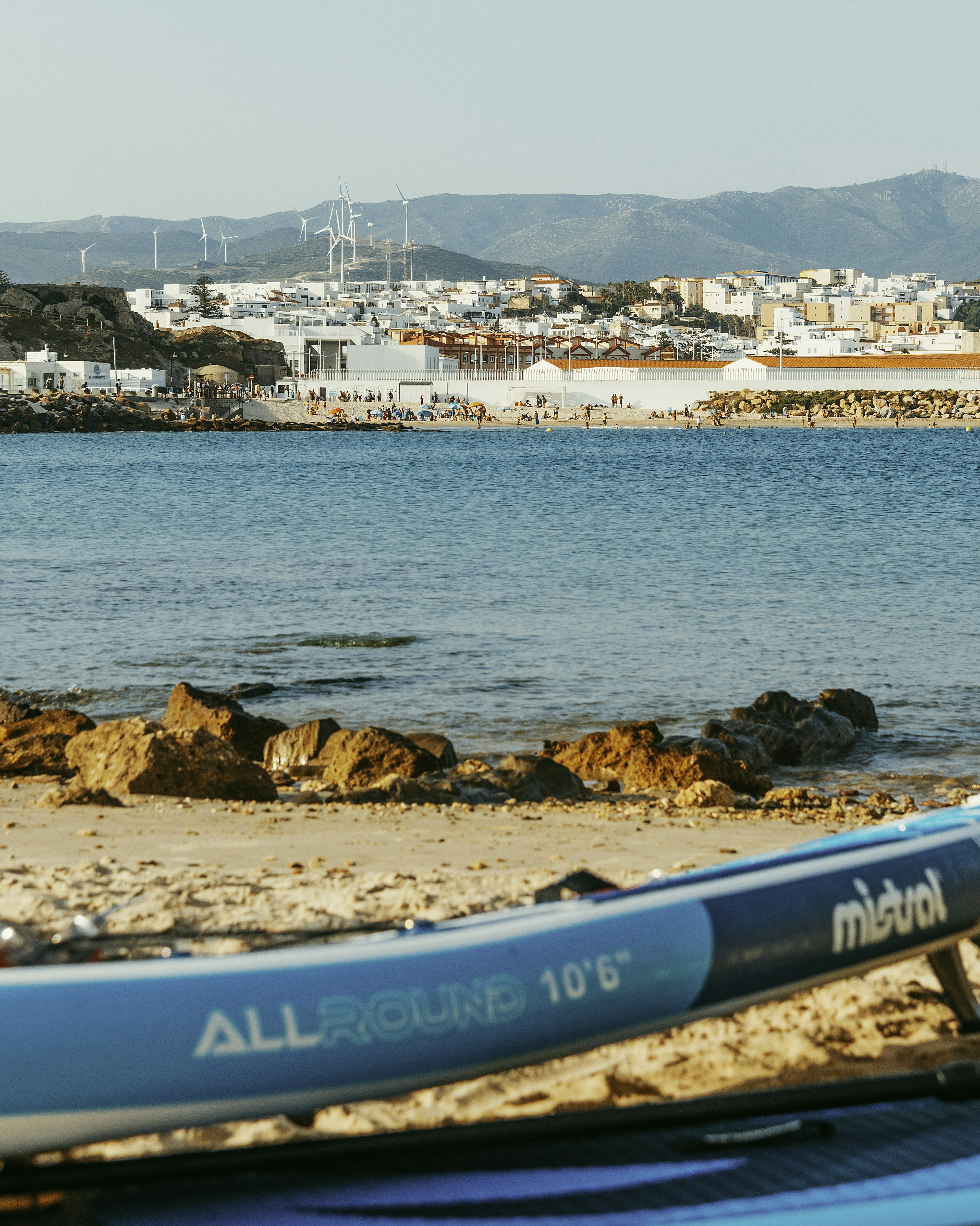 Prancha azul de paddle em uma praia de areia com fundo de oceano