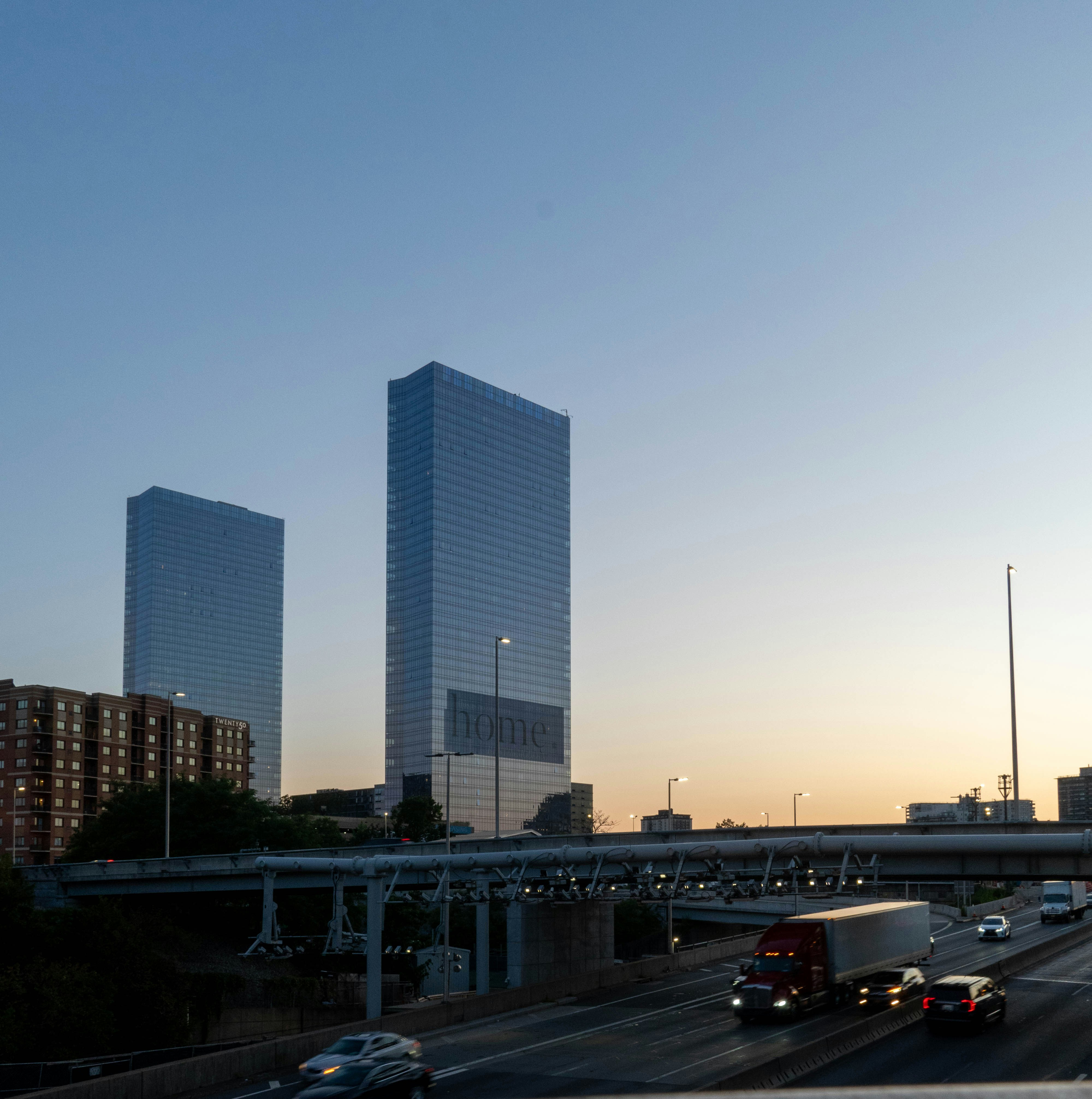 Modern skyscrapers and highway traffic at dusk