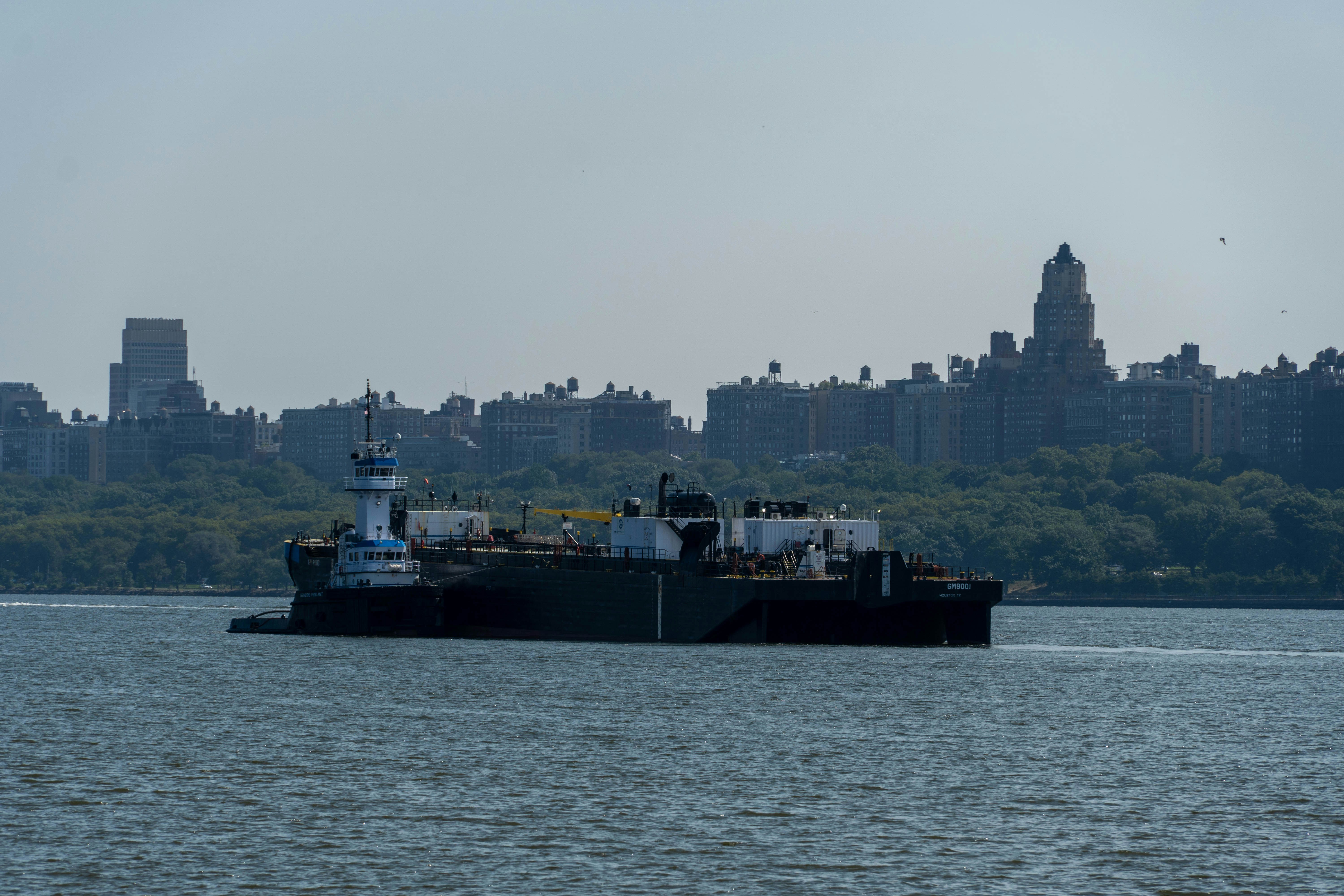 A barge and tugboat sail on the water.