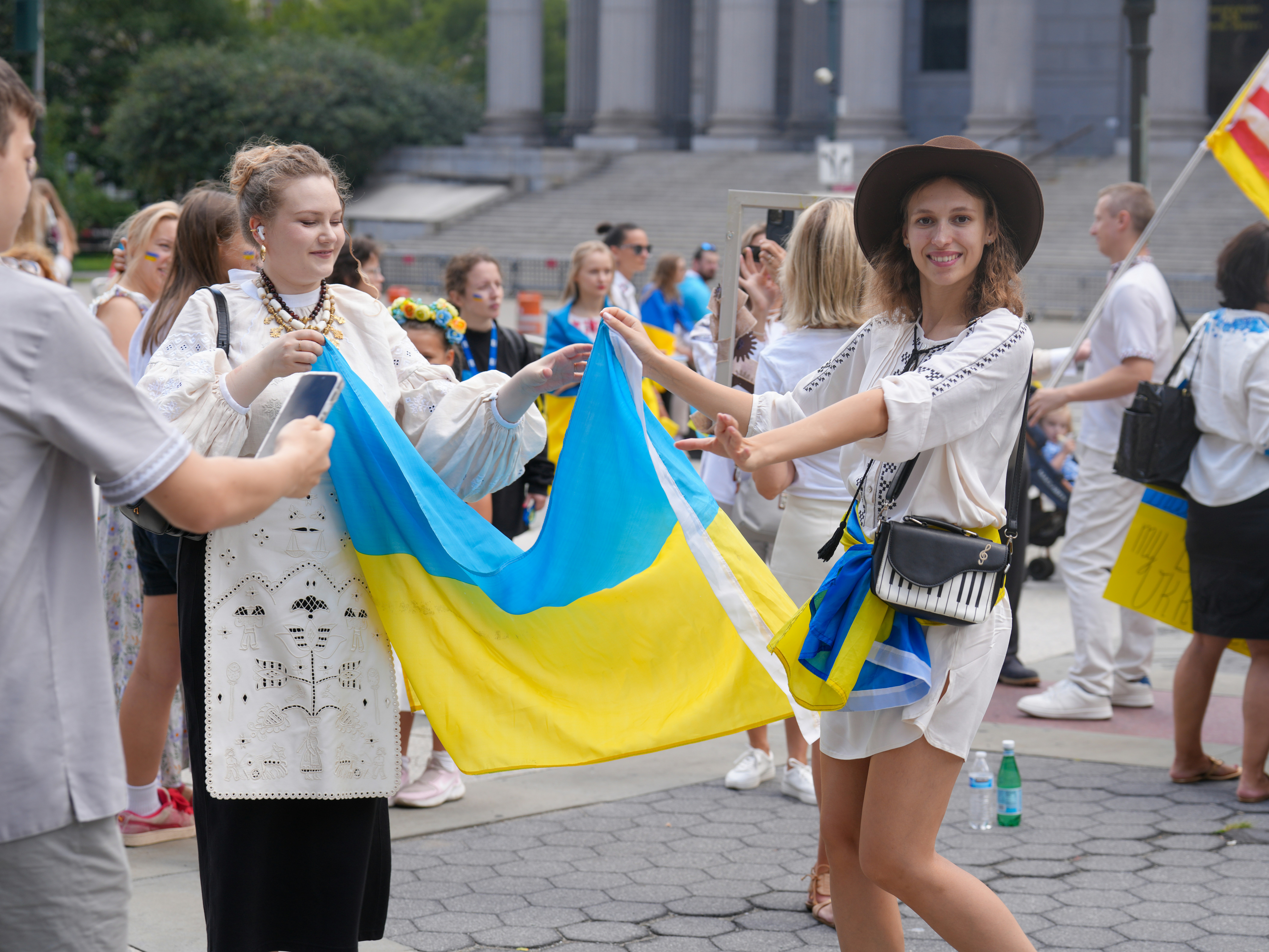 People holding and dancing with a ukrainian flag