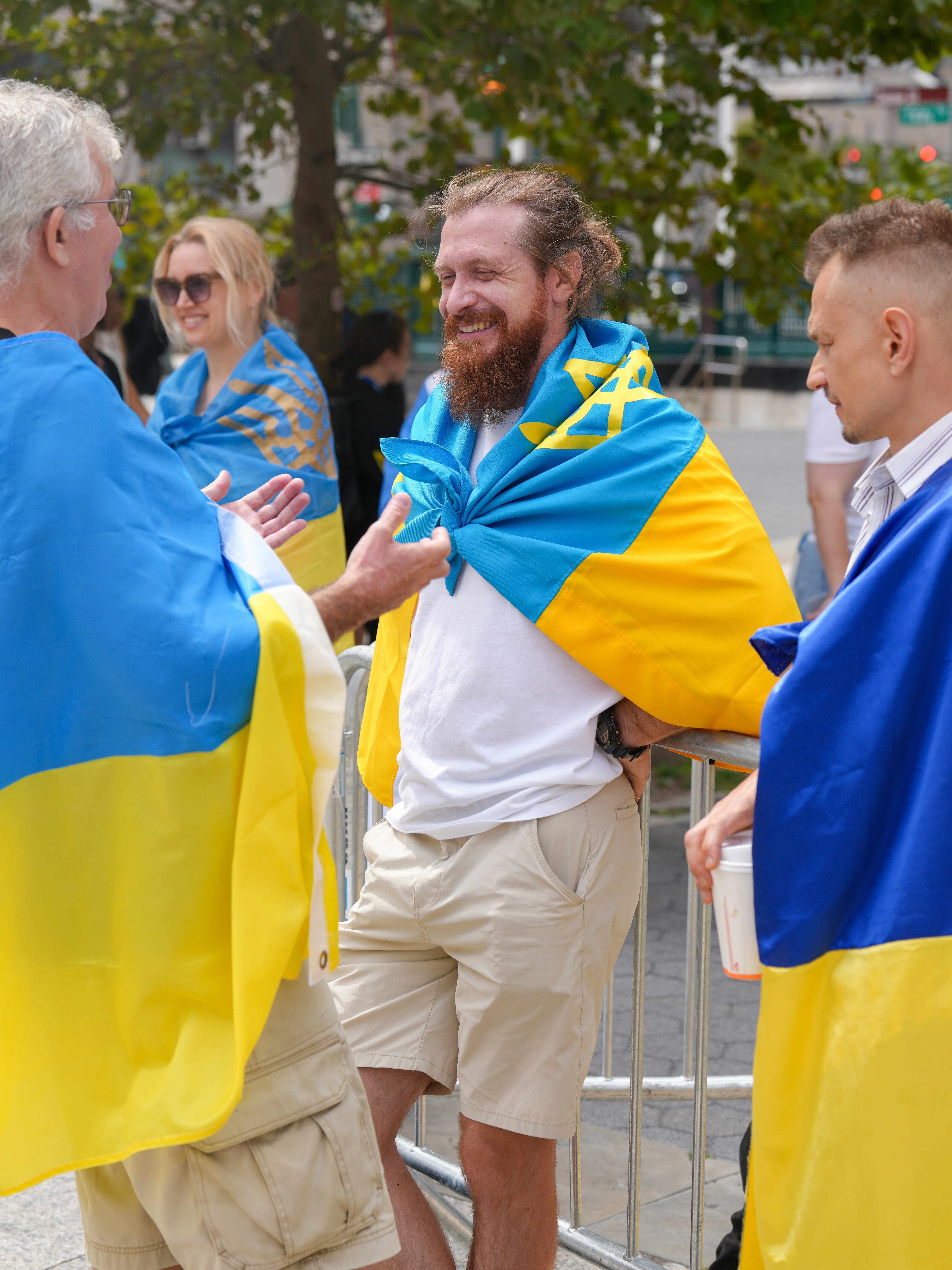 People wearing ukrainian flags in conversation