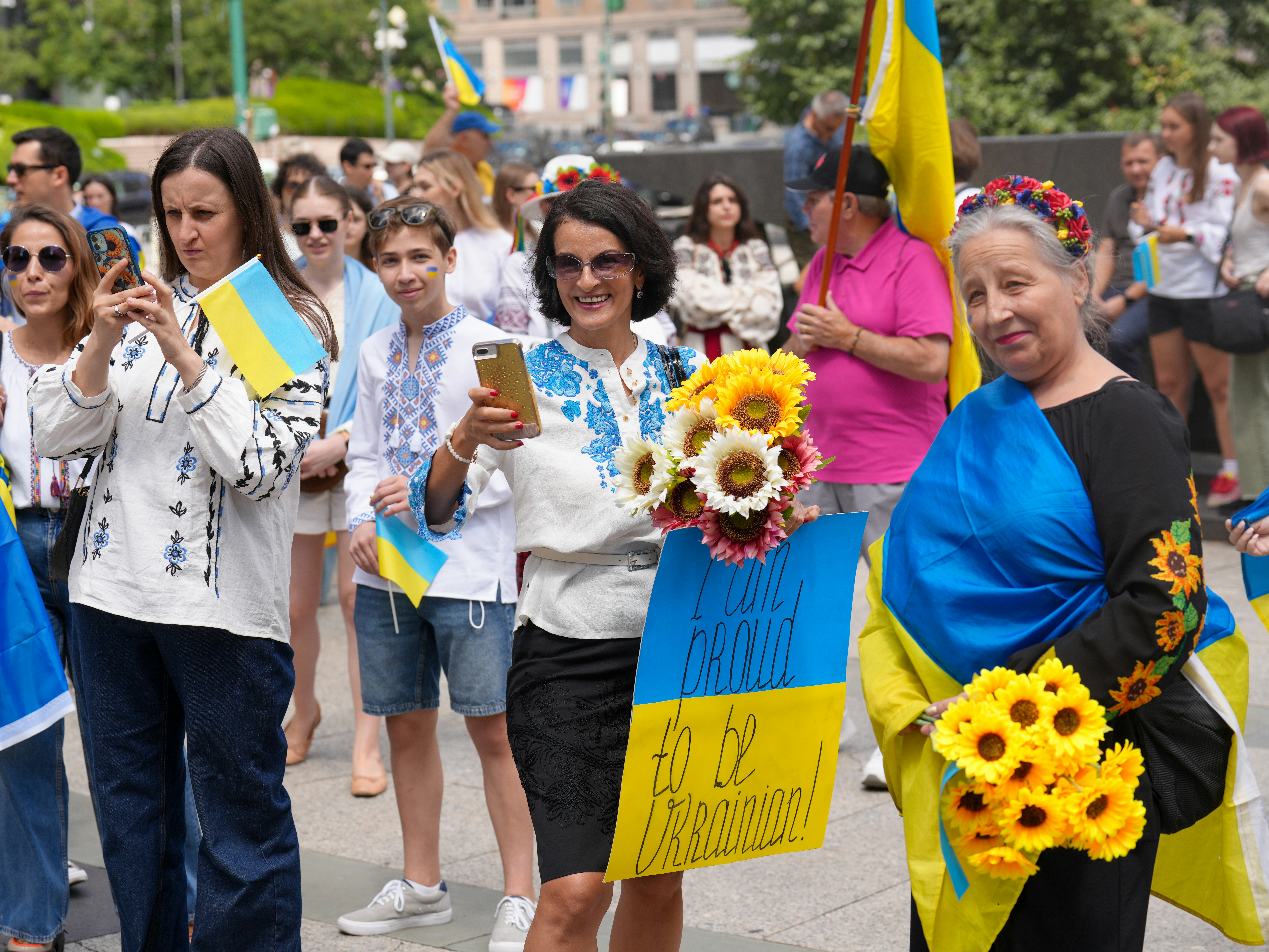 People holding ukrainian flags and sunflowers