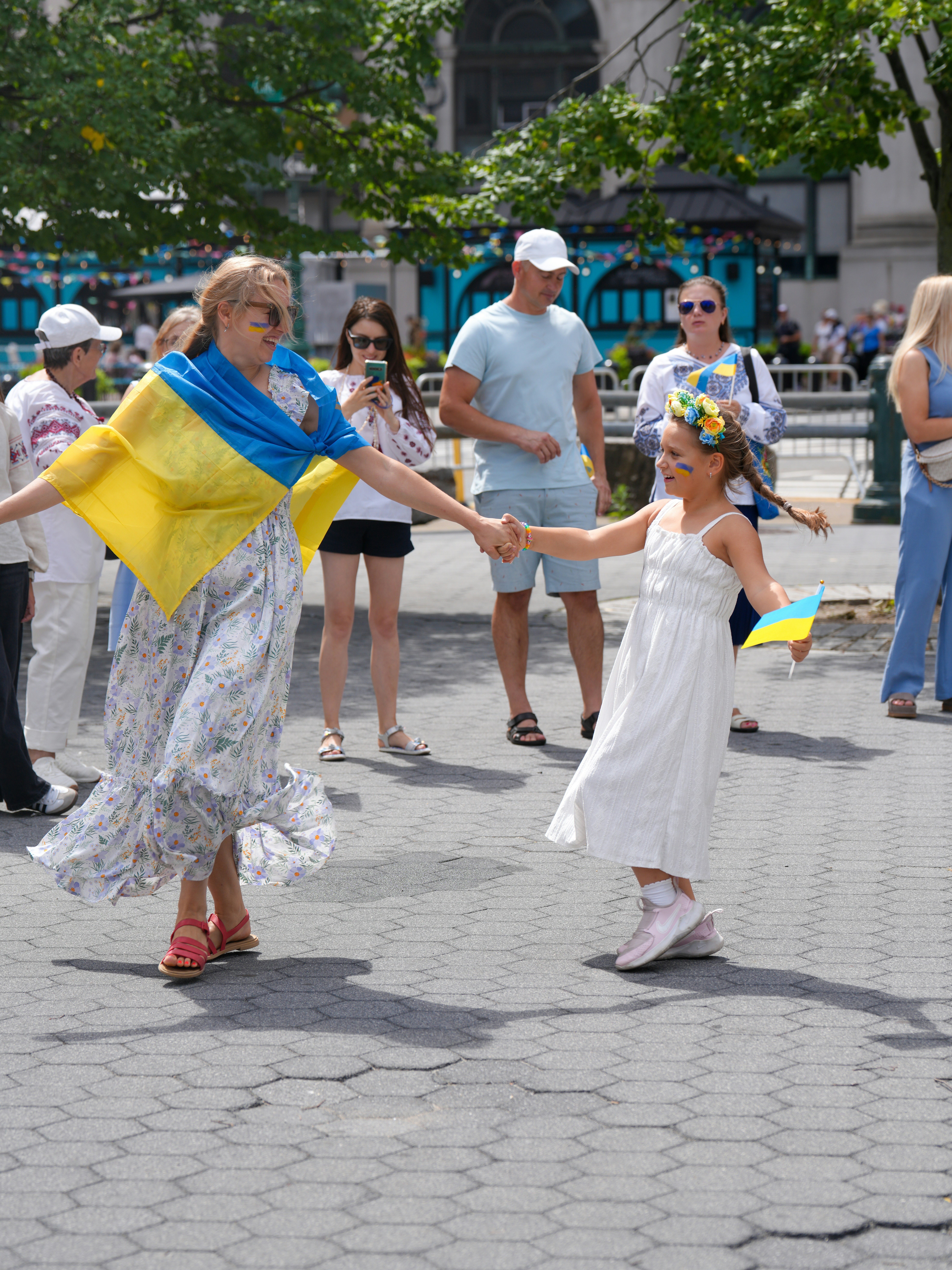 Woman and girl dance with ukrainian flags