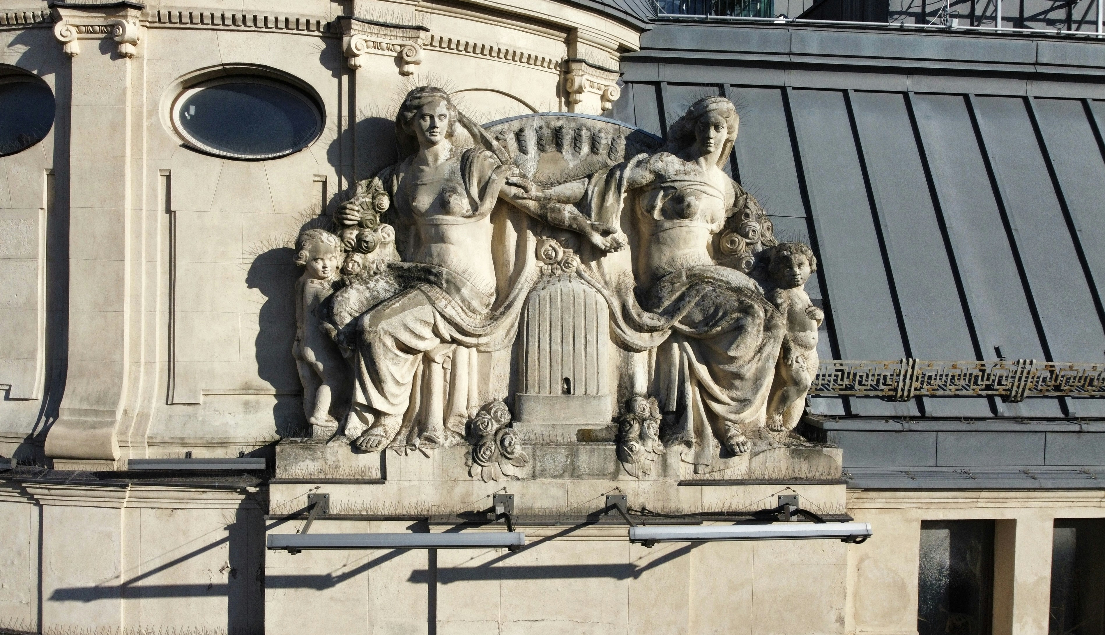 Stone relief sculpture of women and cherubs on building