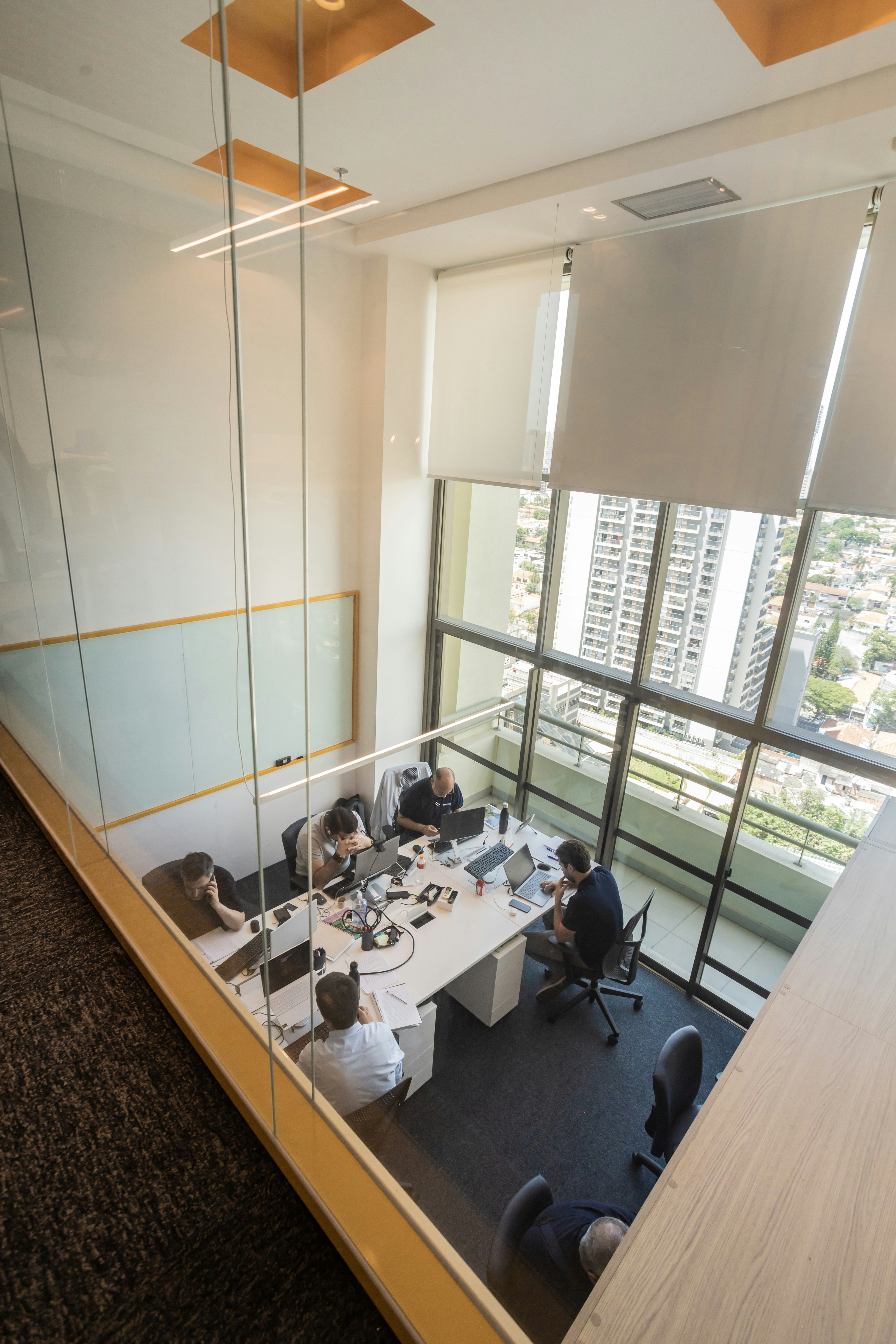 People working in a modern office with large windows.