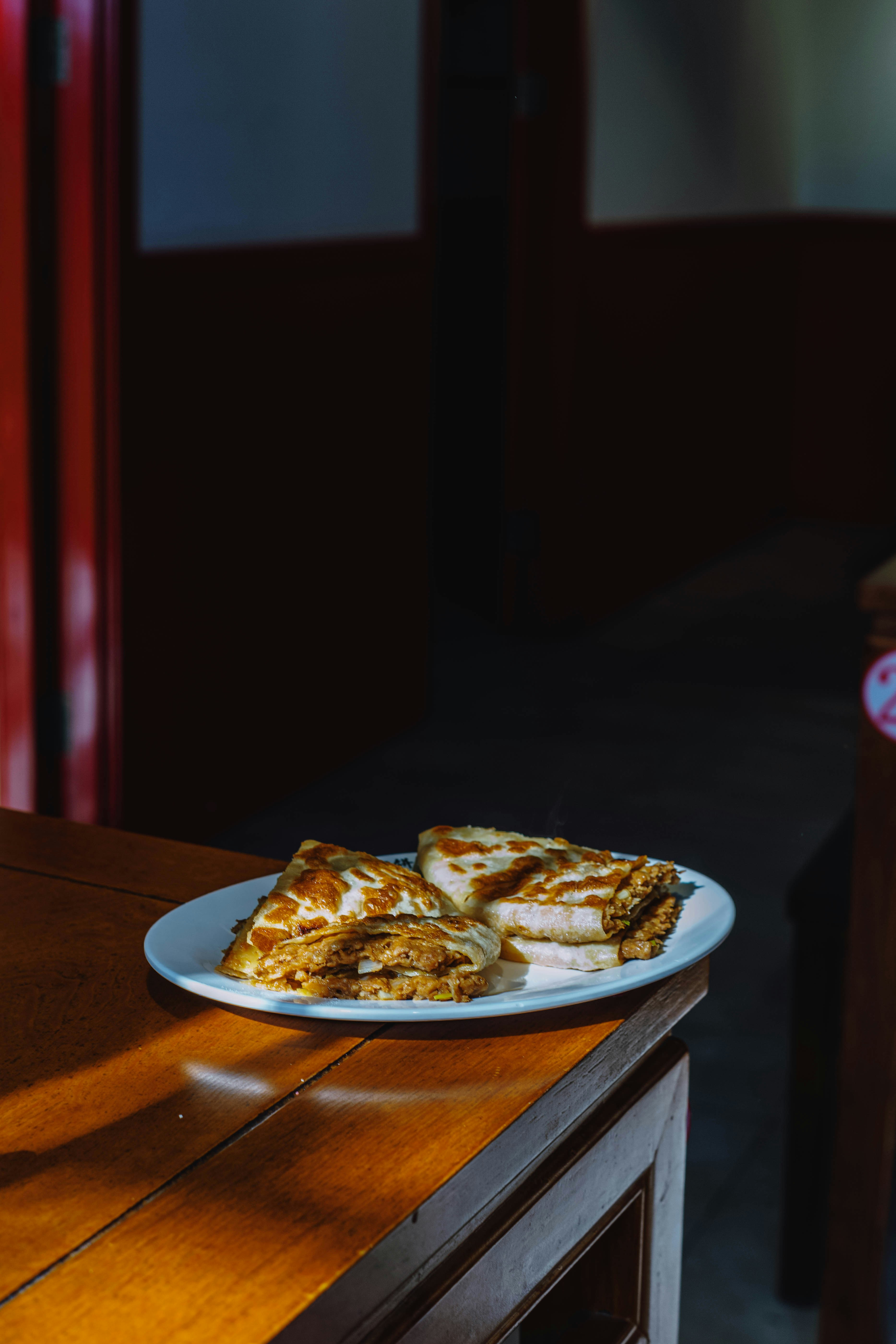 Three slices of folded crepes on a white plate.