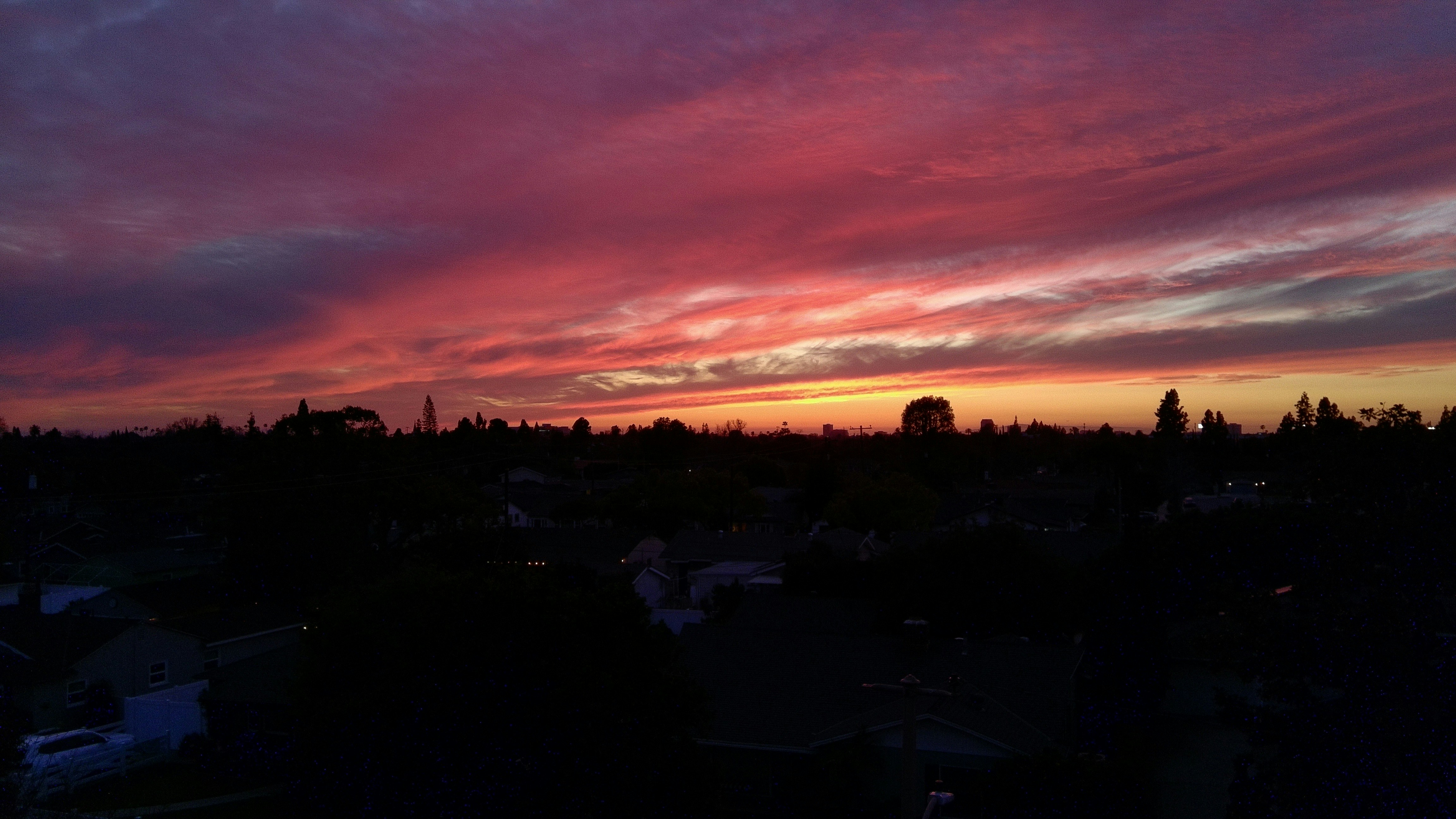 Vibrant sunset sky over a silhouetted landscape.