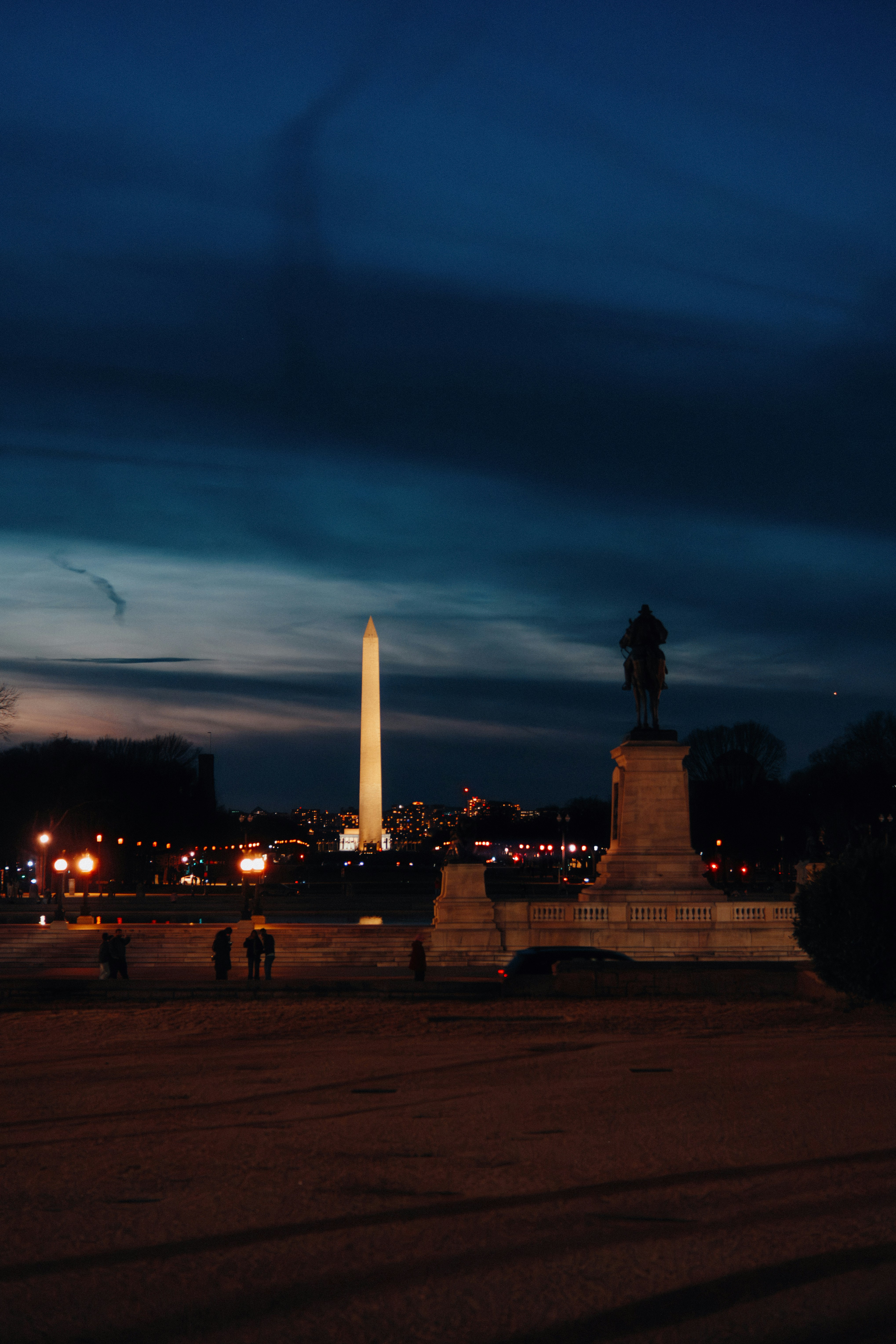 Washington monument and statue at dusk