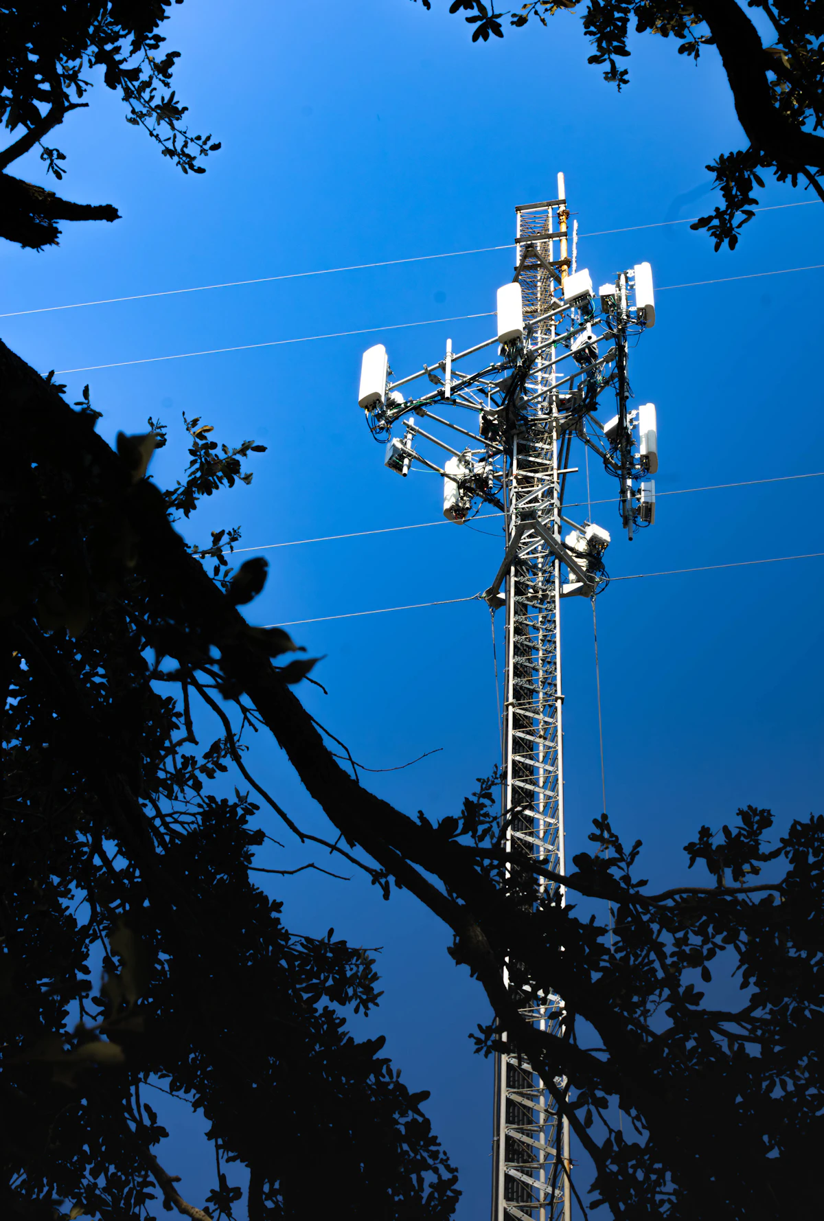 Cell tower with antennas against a clear blue sky