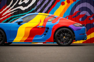 Blue sports car with a vibrant rainbow paint job.