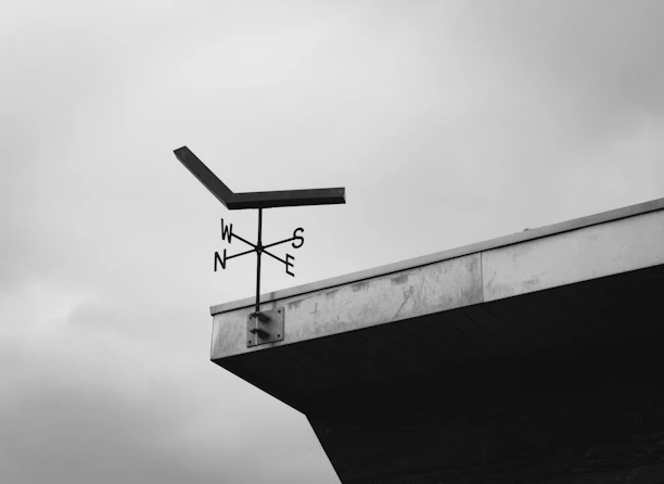 A weather vane on a building edge