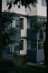 Modern apartment building with dark grey accents and trees