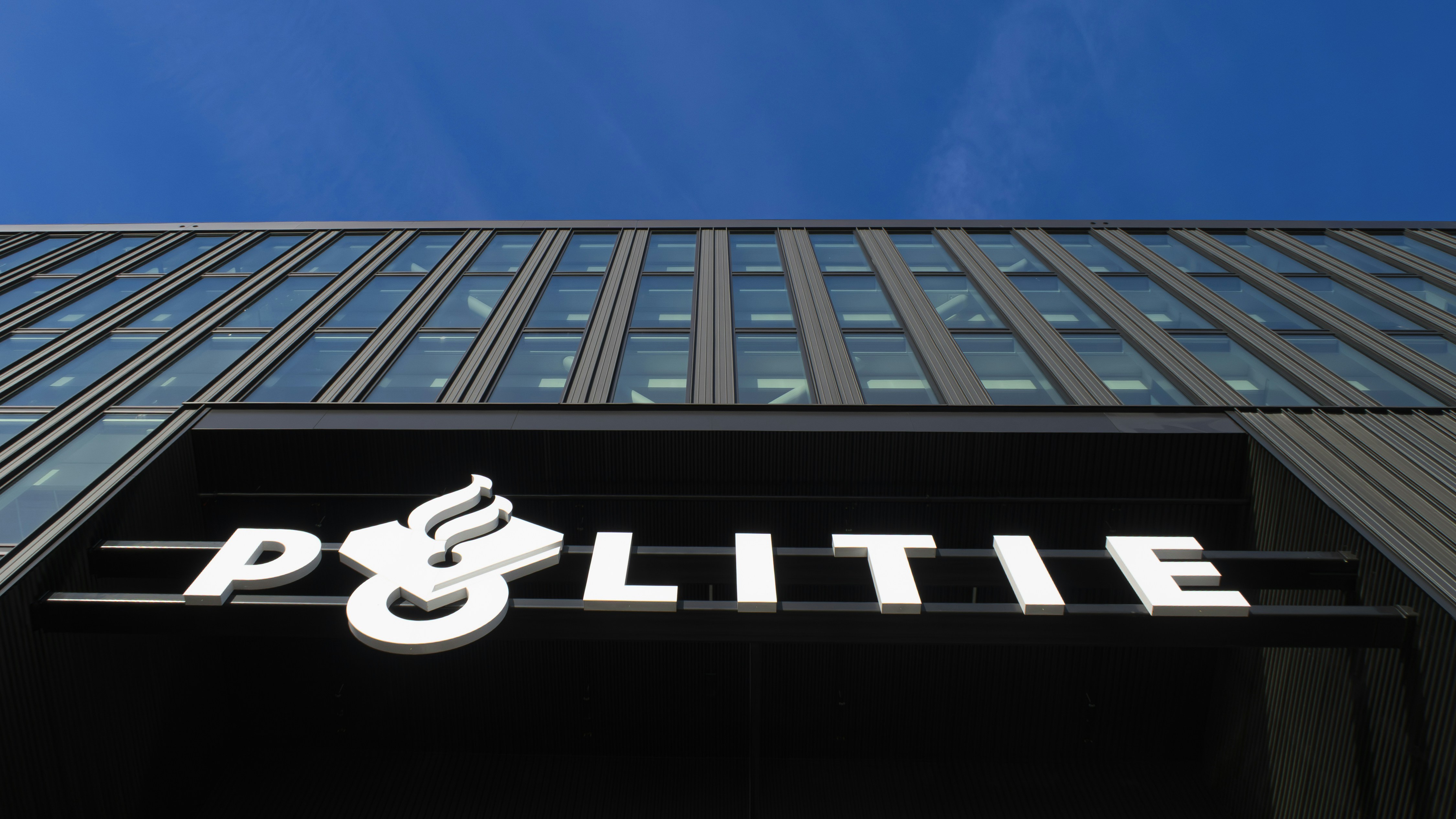 Modern building with "politie" sign under blue sky