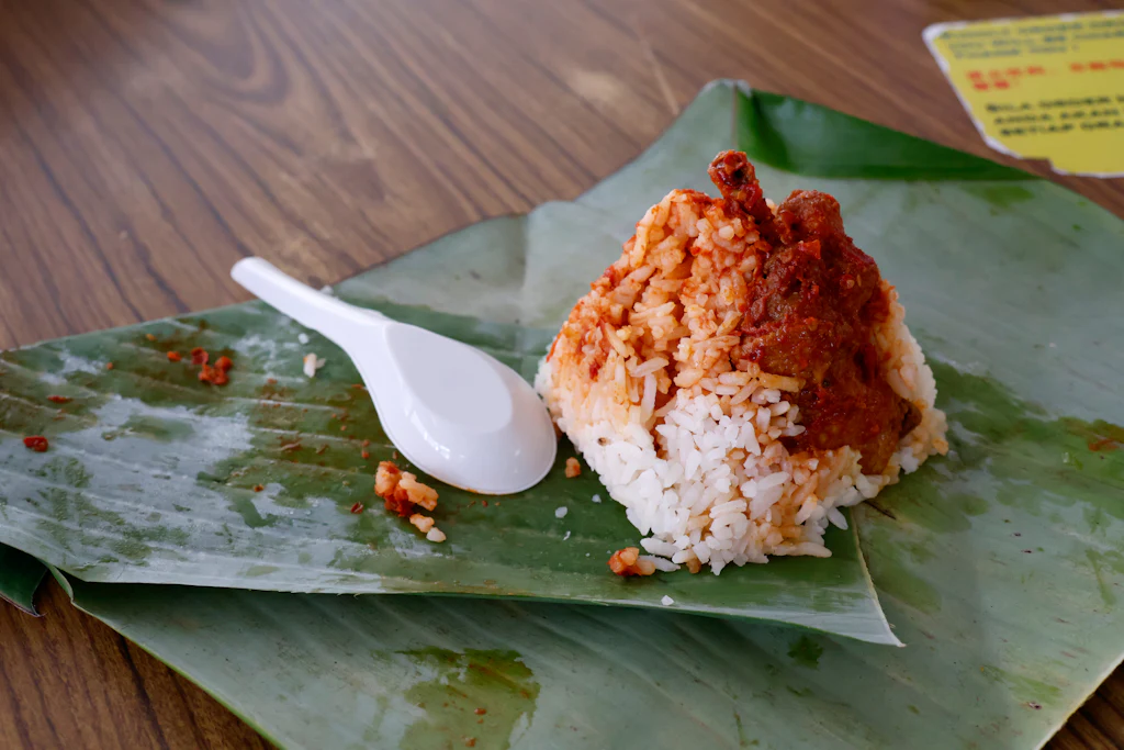 Nasi lemak with coconut rice, sambal and chicken served on a banana leaf in George Town