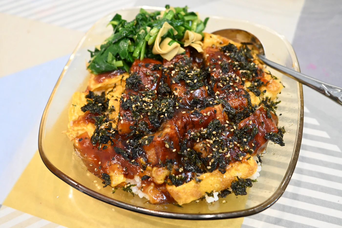 Teriyaki chicken rice bowl with egg sesame and greens