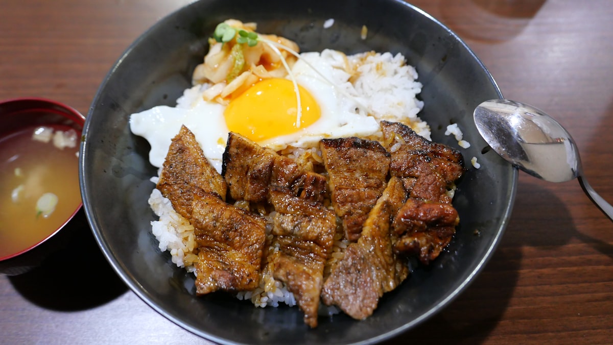 밥과 고기, 계란이 담긴 한 그릇 식사