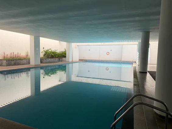 Indoor swimming pool with clear blue water.