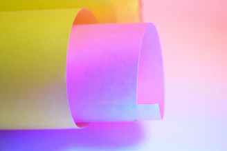 Rolled yellow and pink paper with colorful lighting