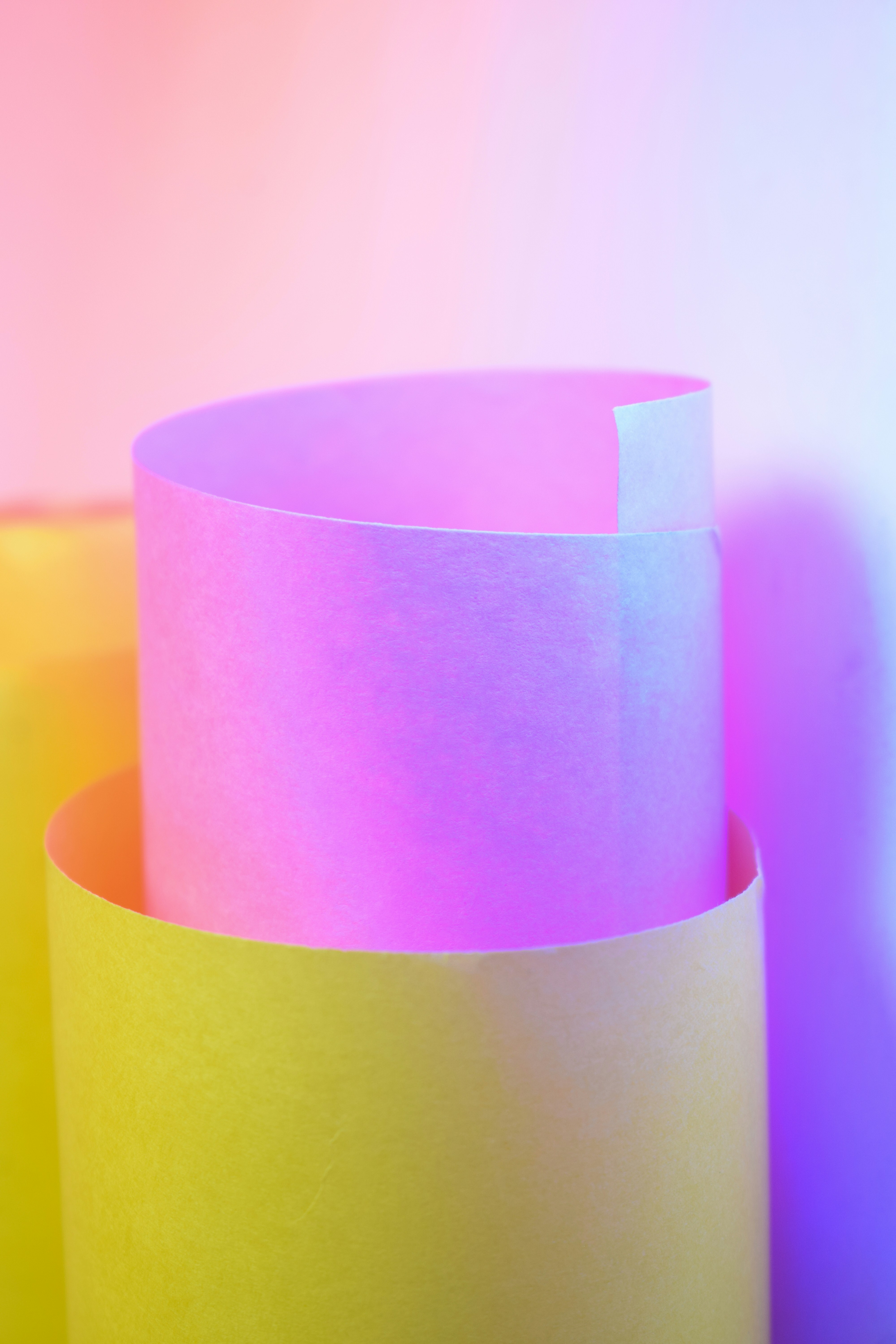 Carta gialla e rosa arrotolata con luce soffusa