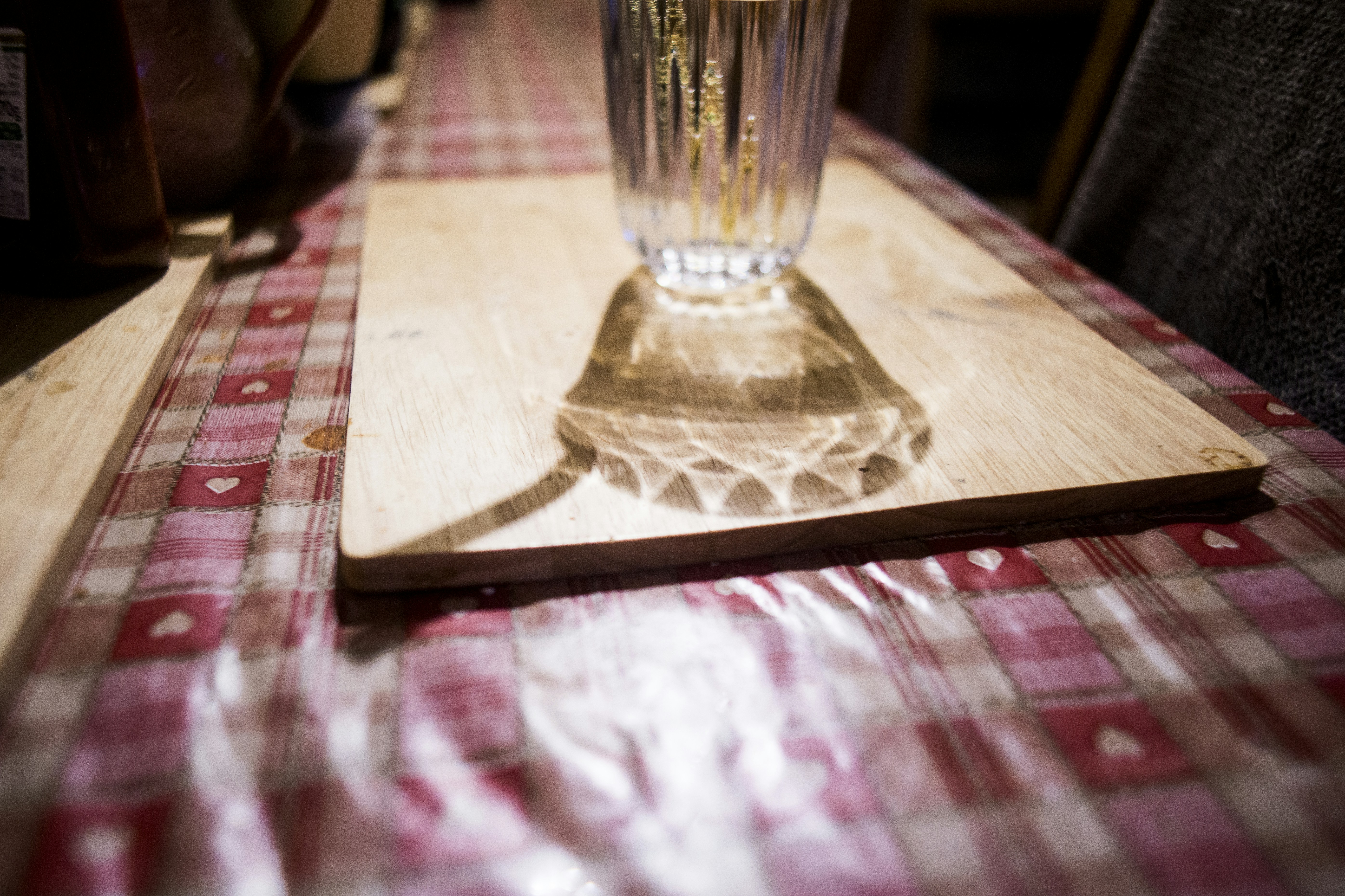Ein Glas Wasser warf einen Schatten auf einen Tisch
