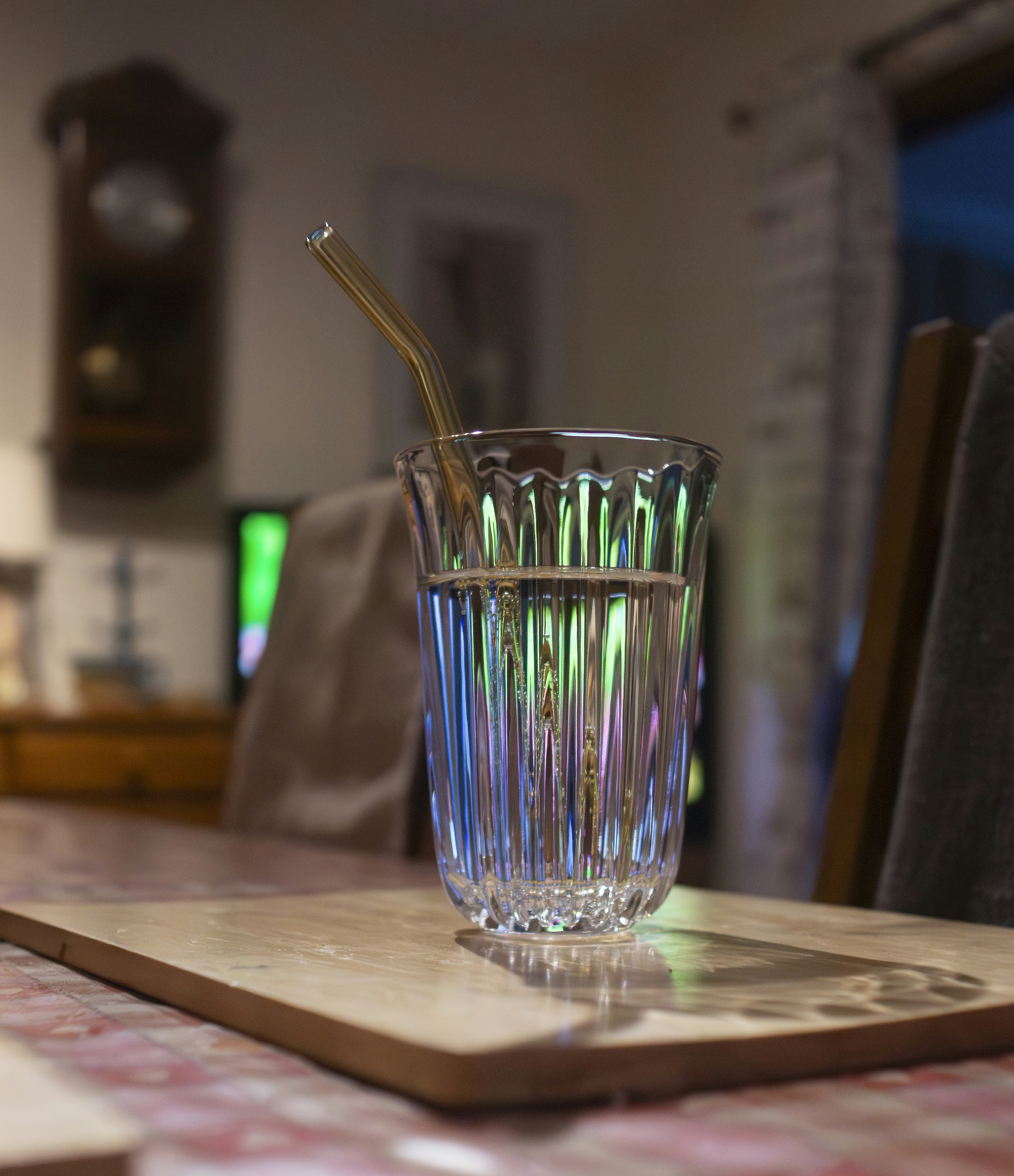 Glas Wasser mit Stroh auf dem Tisch