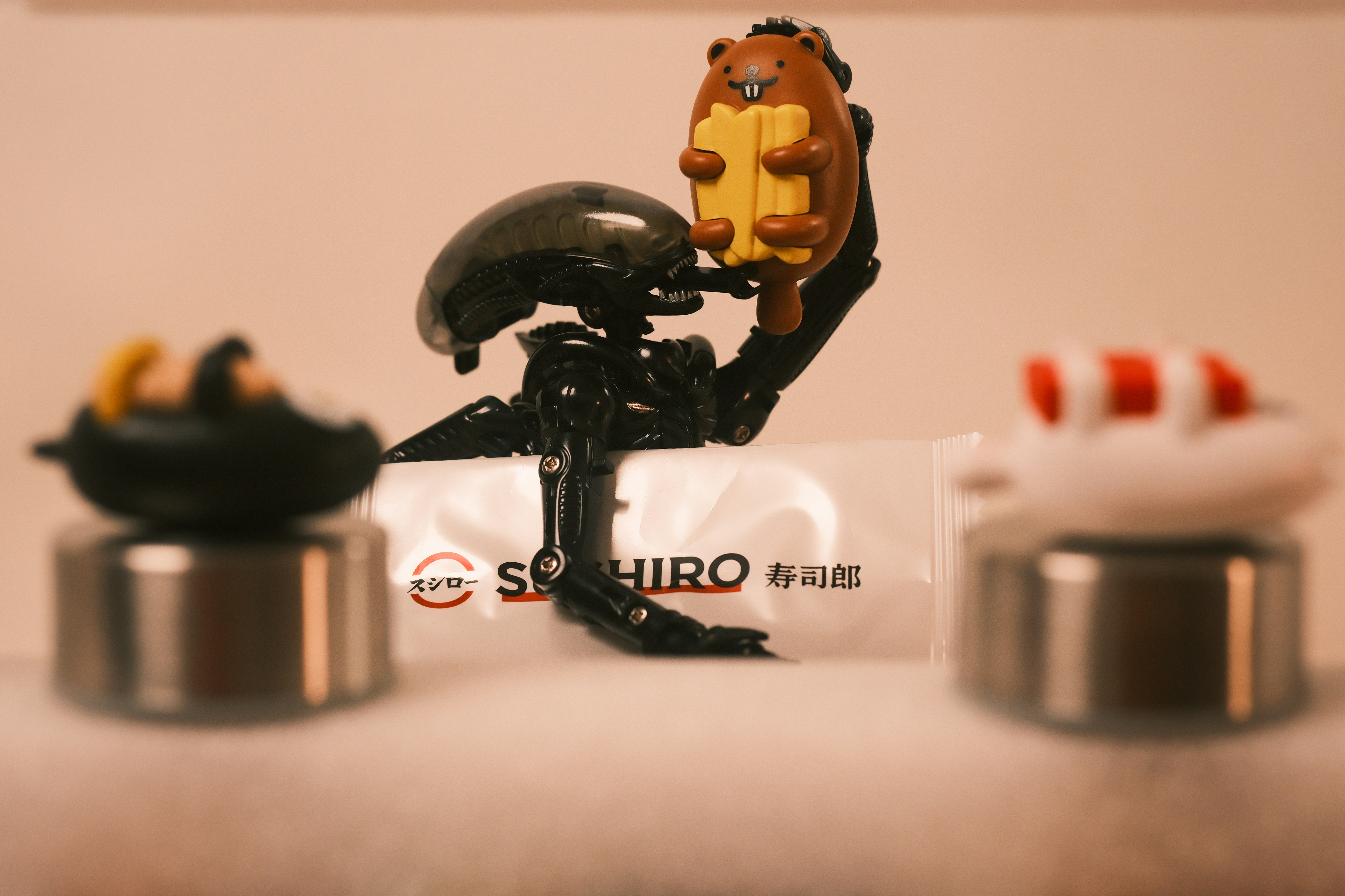 Alien figurine holding a hot dog with small figurines