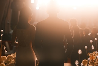 Couple walking towards bright light with floral decorations
