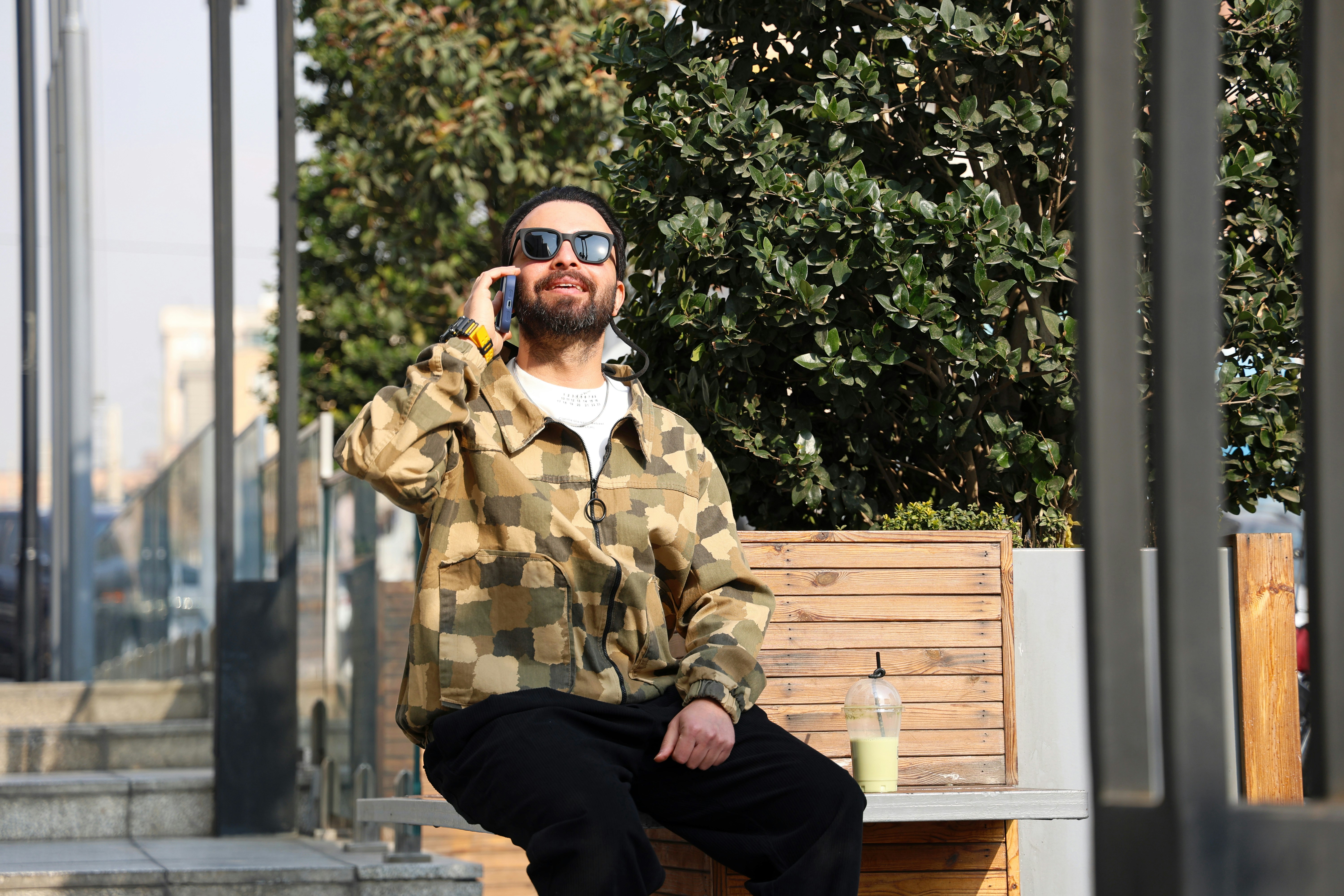 Man in sunglasses talking on phone outdoors