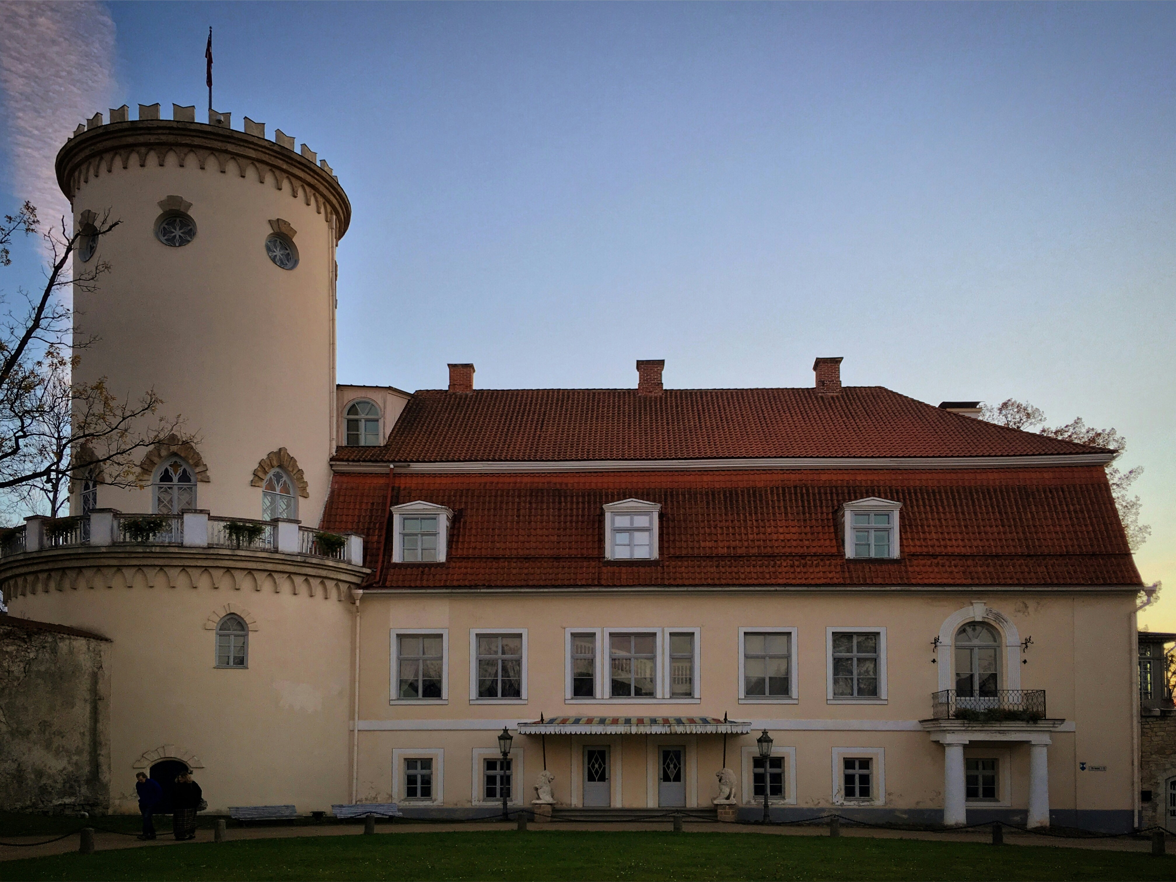 A large cream-colored castle with a round tower.
