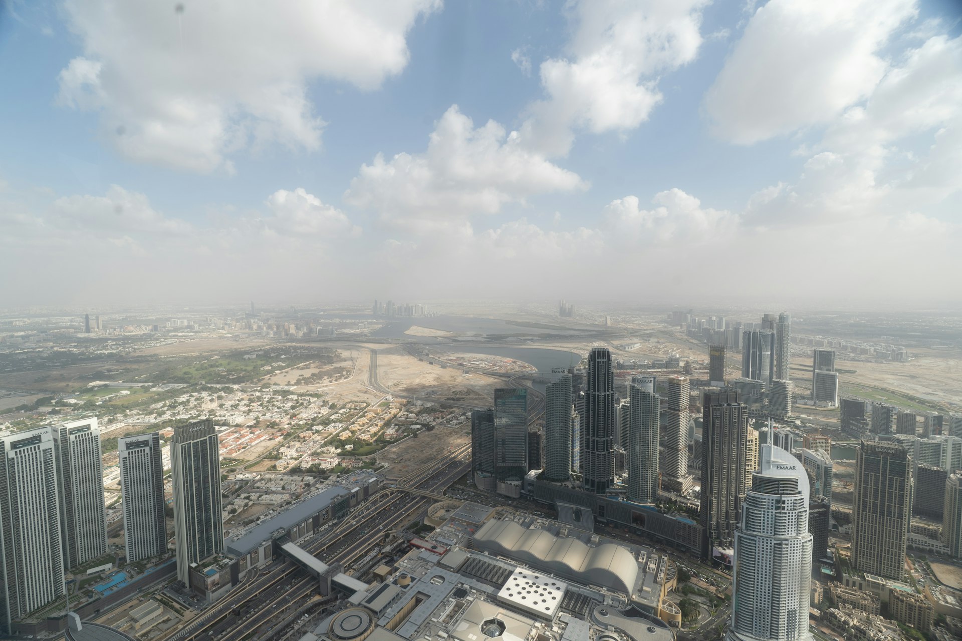 Modern skyscrapers rise above a sprawling desert cityscape.