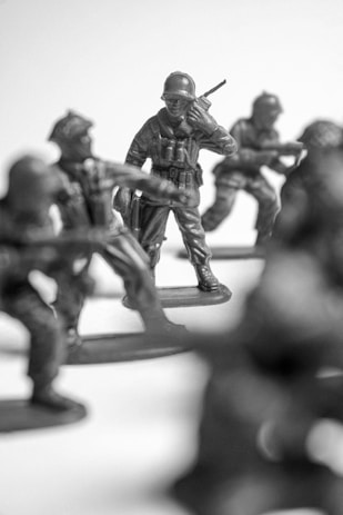 Toy soldiers in formation with one holding a radio.