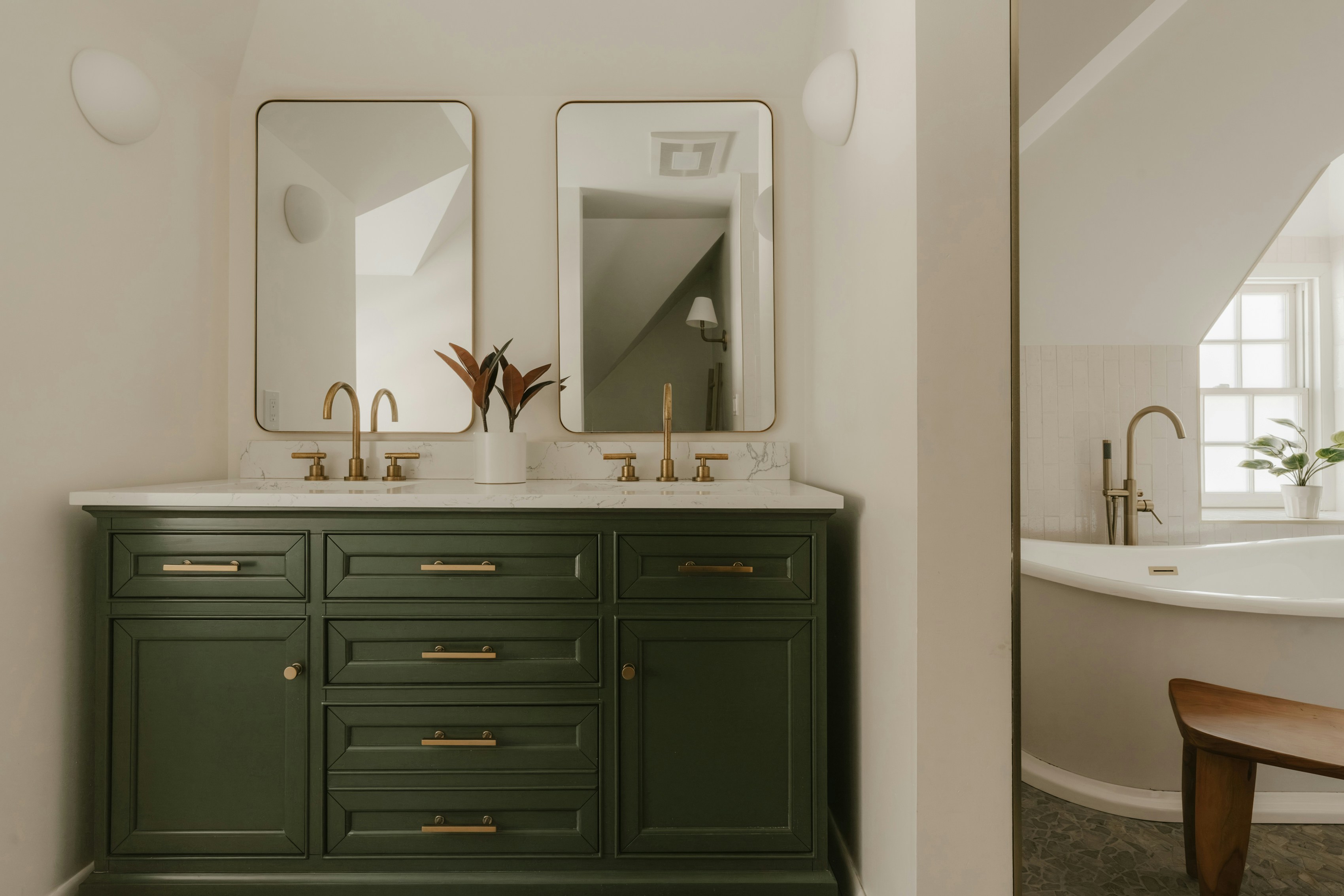 A modern bathroom vanity with two sinks and mirrors.