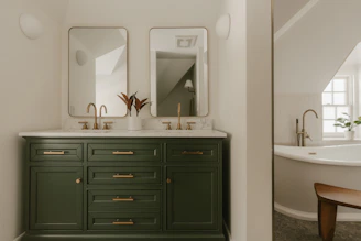 A modern bathroom vanity with two sinks and mirrors.
