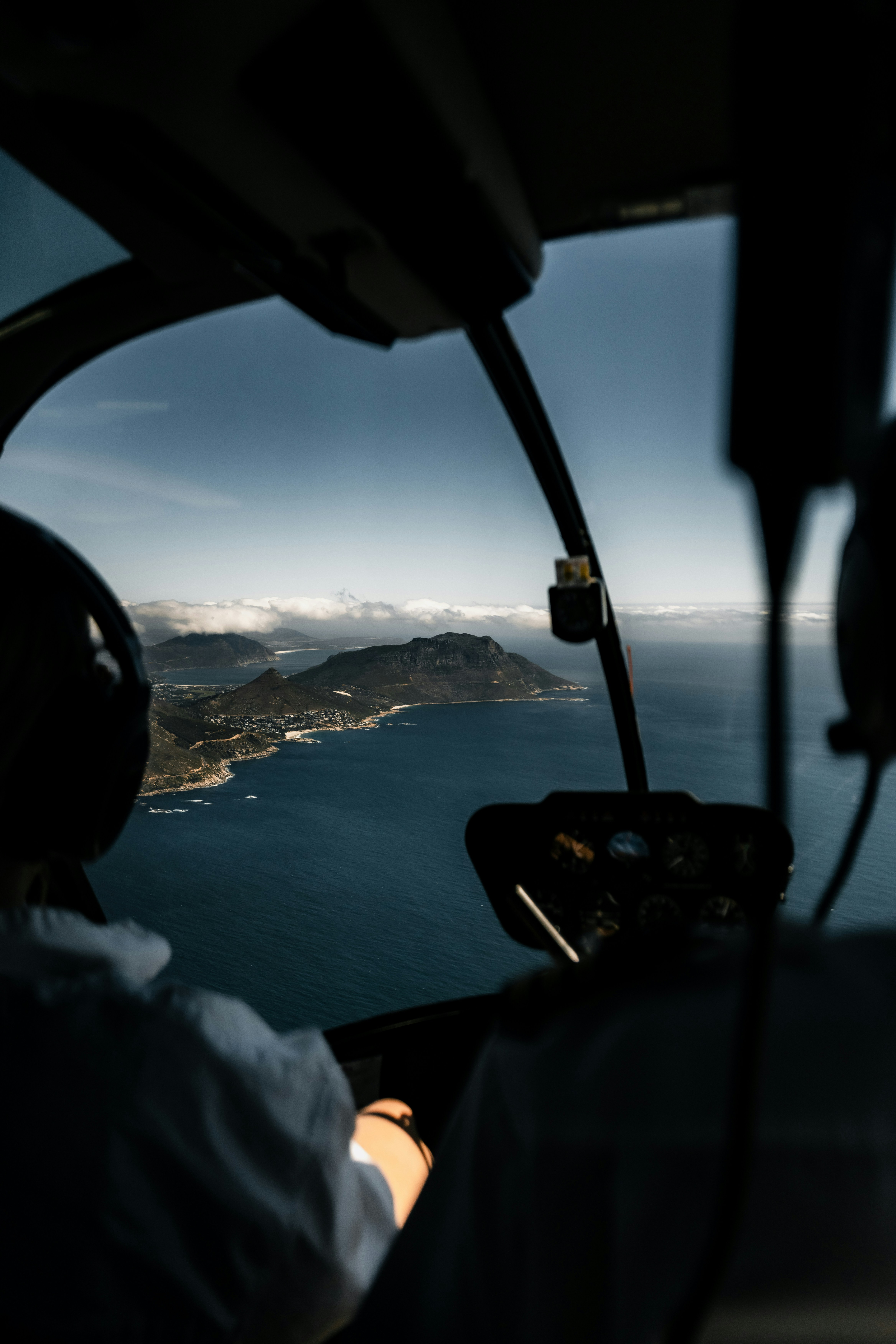 View from helicopter cockpit over coastal mountains