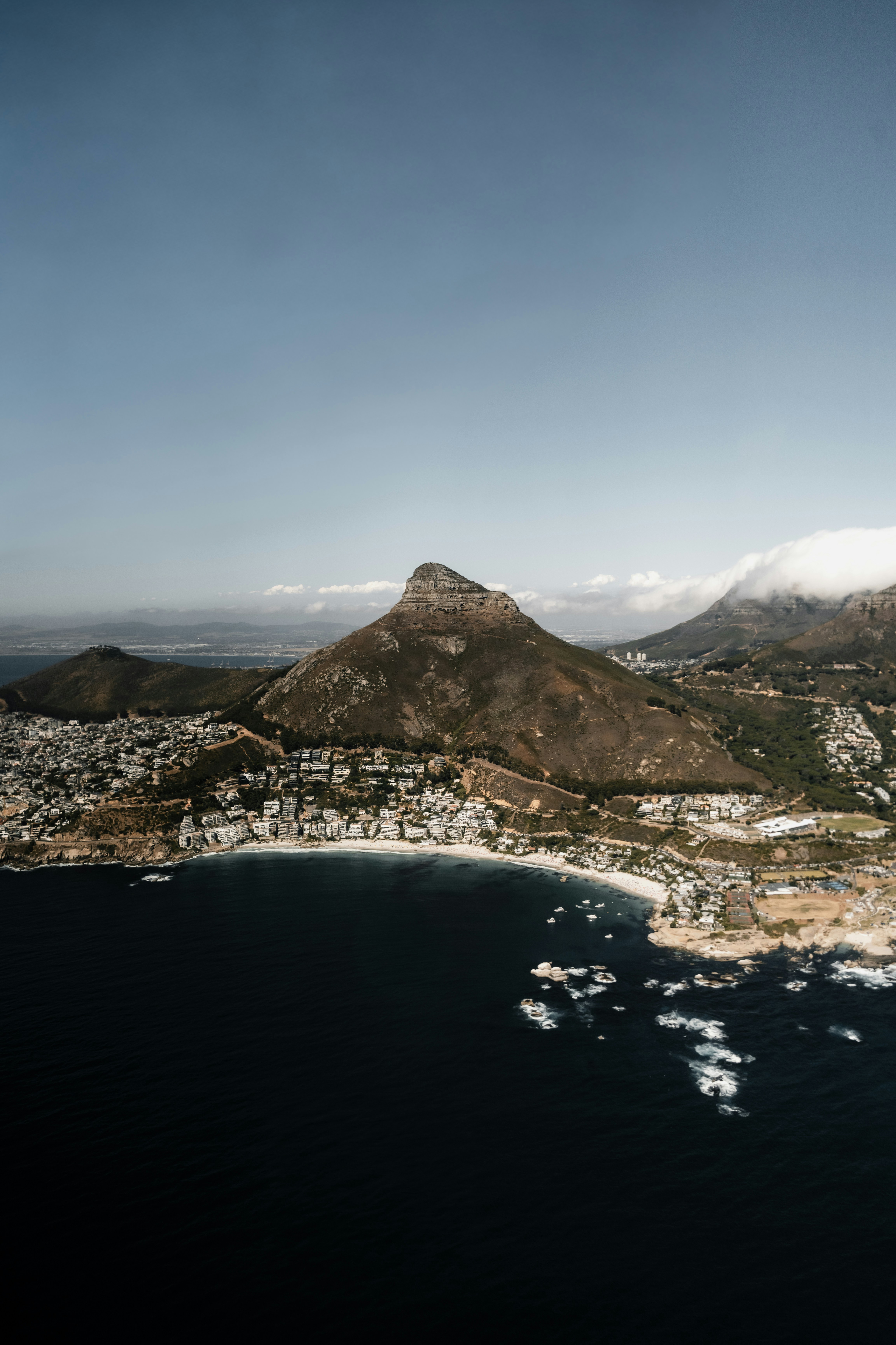 Aerial view of a coastal city with a prominent mountain.